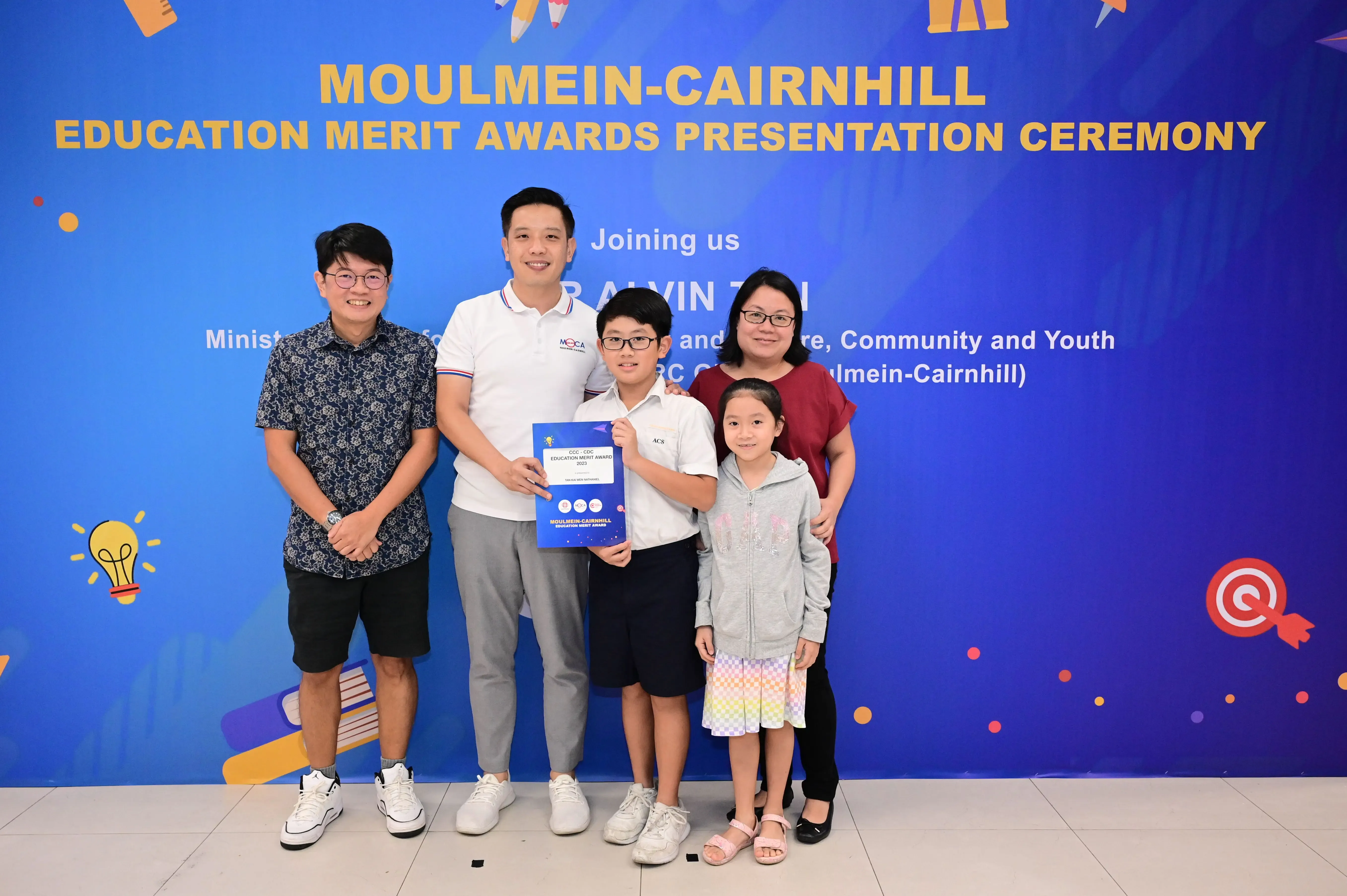 Five people pose with an award certificate at the Moulmein-Cairnhill Education Merit Awards Presentation Ceremony.