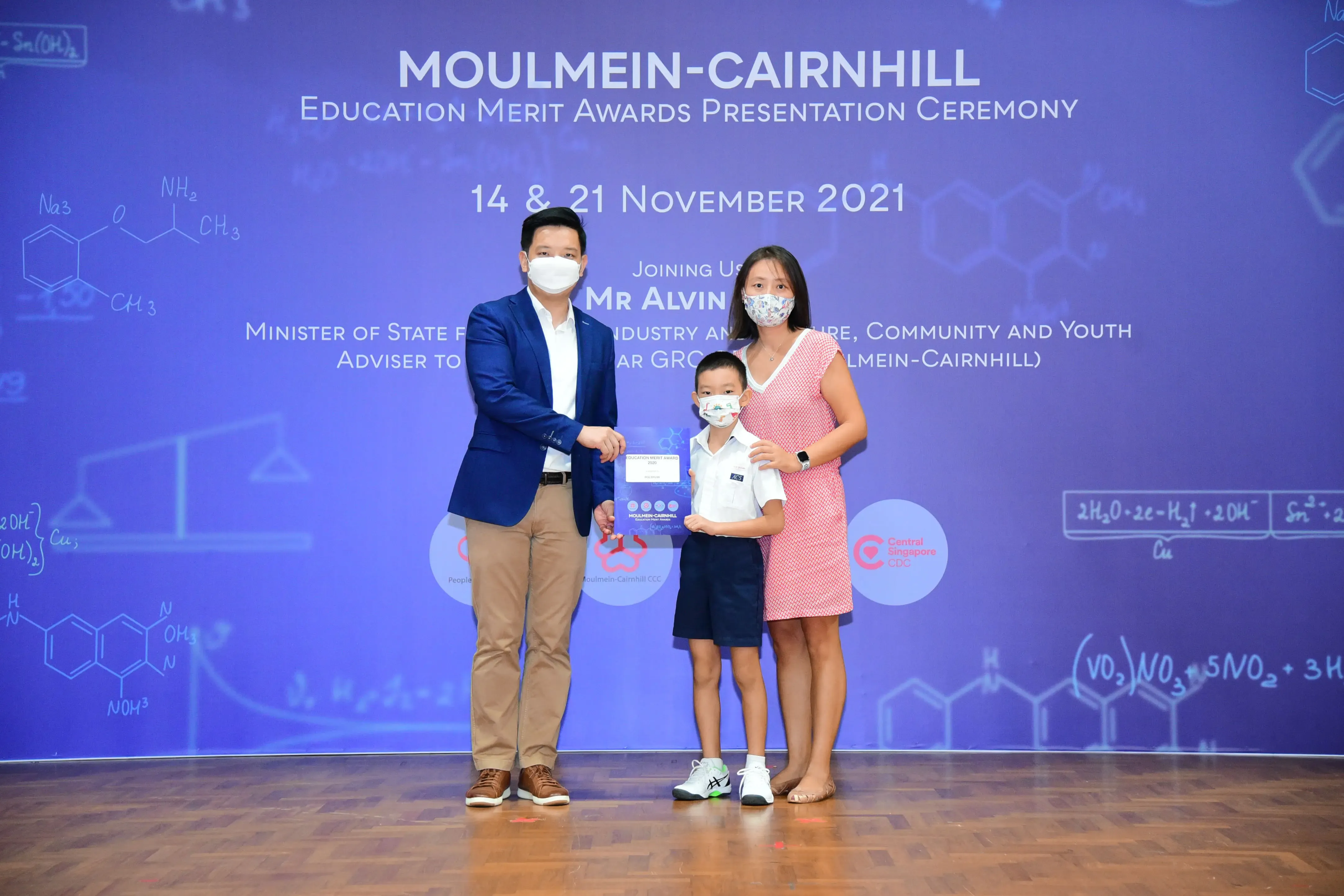 Three masked people pose at the Moulmein-Cairnhill Education Merit Awards Ceremony on November 2021.