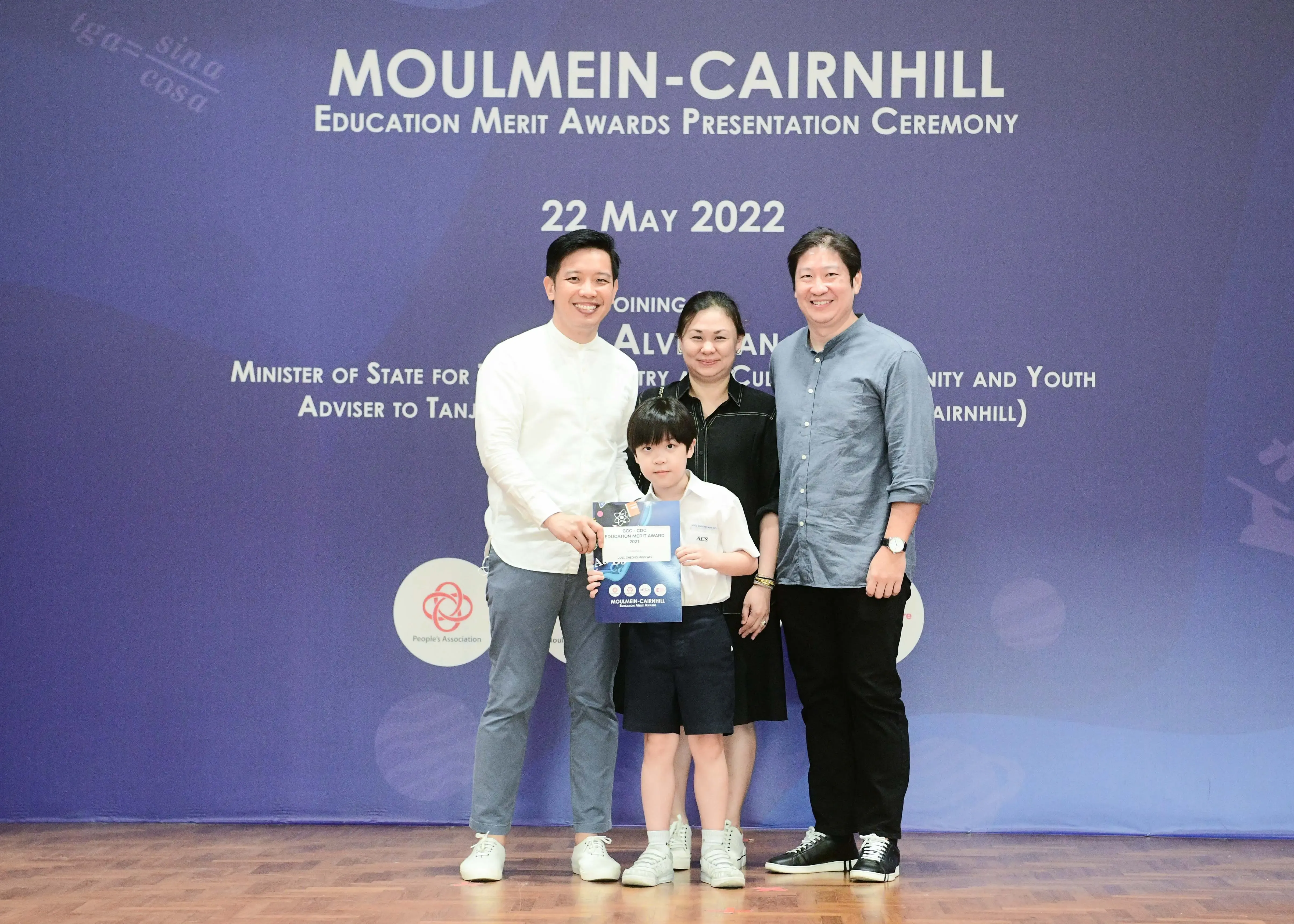 Four people pose with an award certificate at the Moulmein-Cairnhill Education Merit Awards on 22 May 2022.