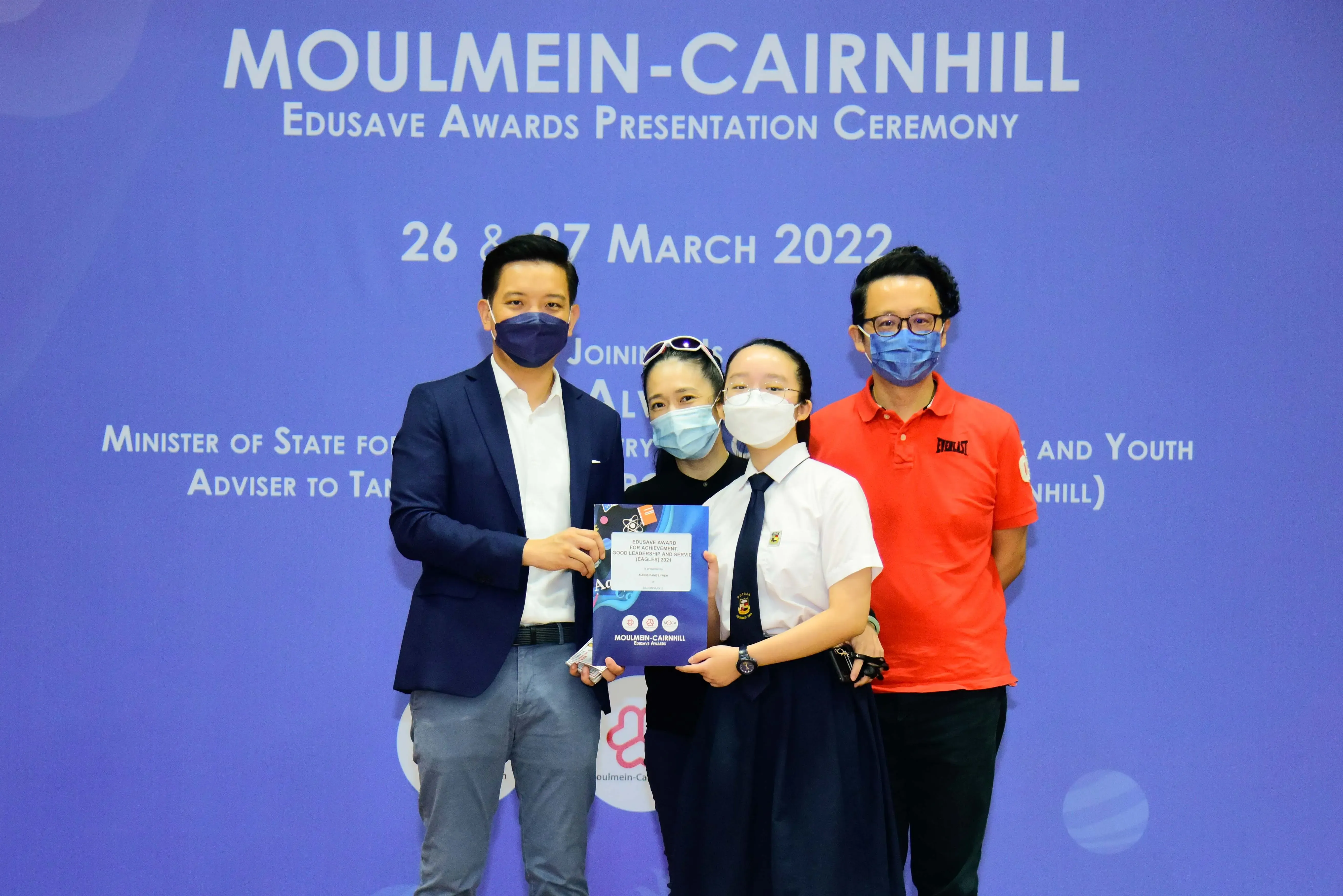 Four masked people pose at the Moulmein-Cairnhill Edusave Awards Presentation Ceremony on March 26-27, 2022.