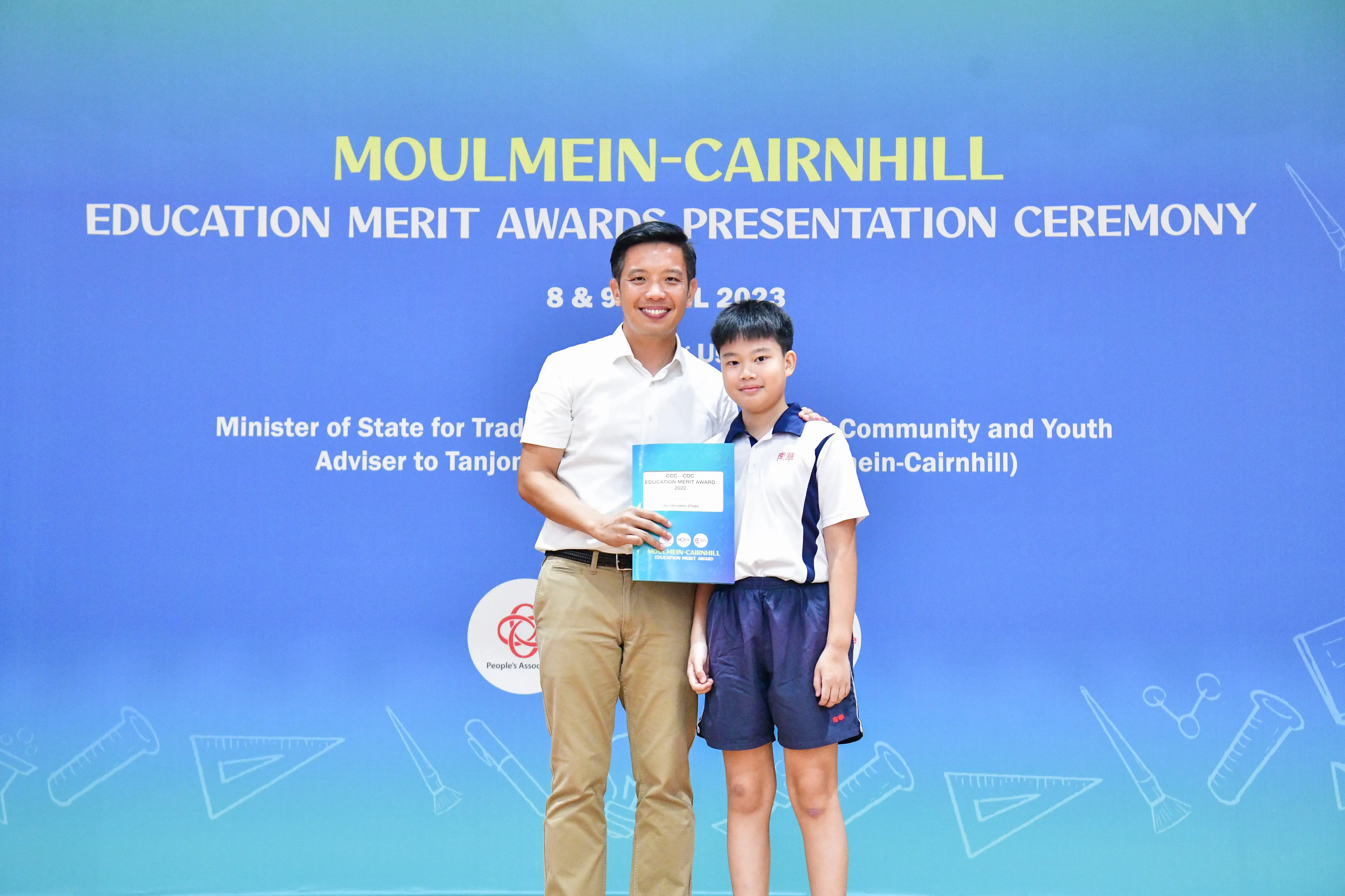 An adult and a young student pose together holding an award at the Moulmein-Cairnhill Education Merit Awards 2023.