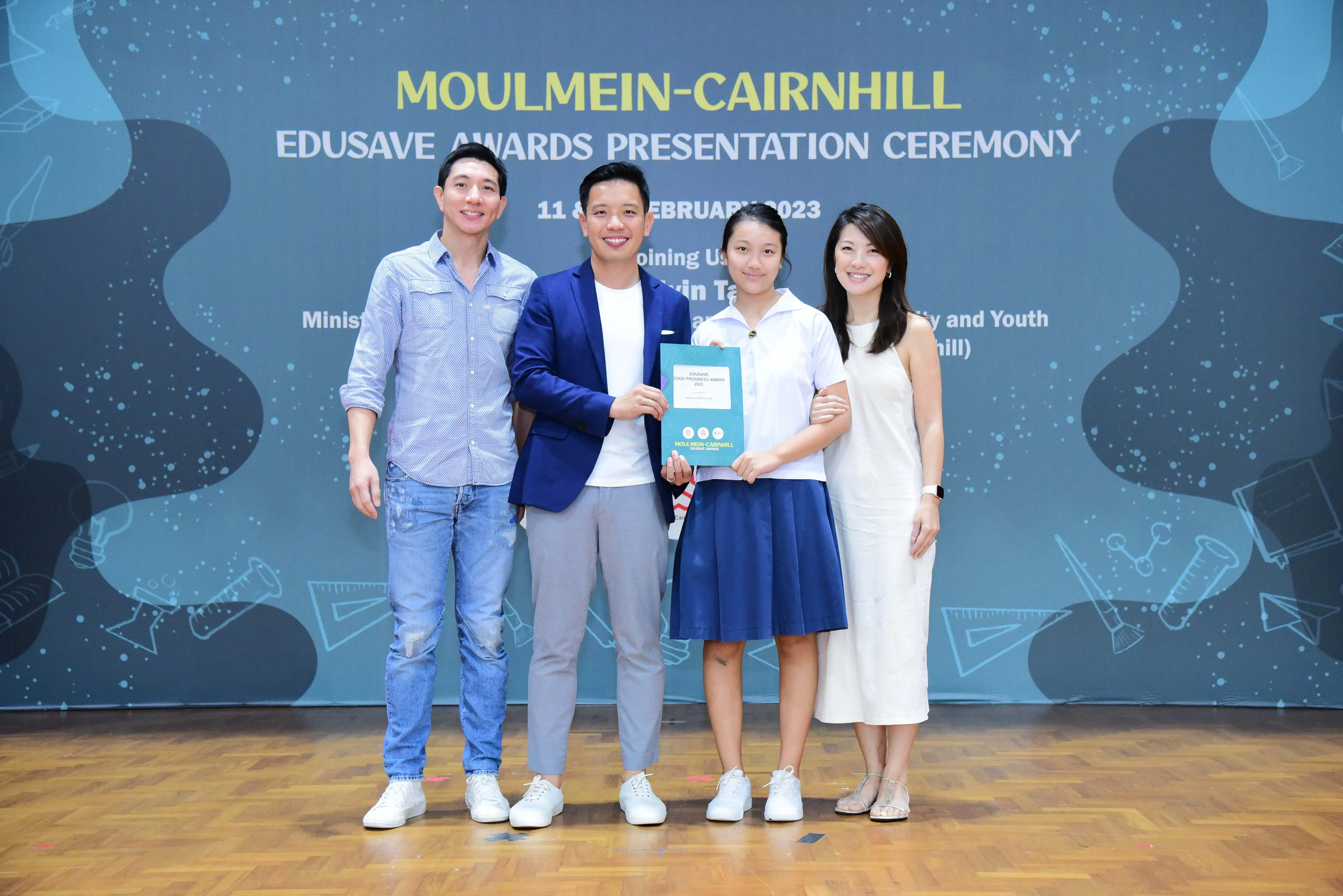 Four people pose smiling at the Moulmein-Cairnhill Edusave Awards Presentation Ceremony on 11 February 2023.