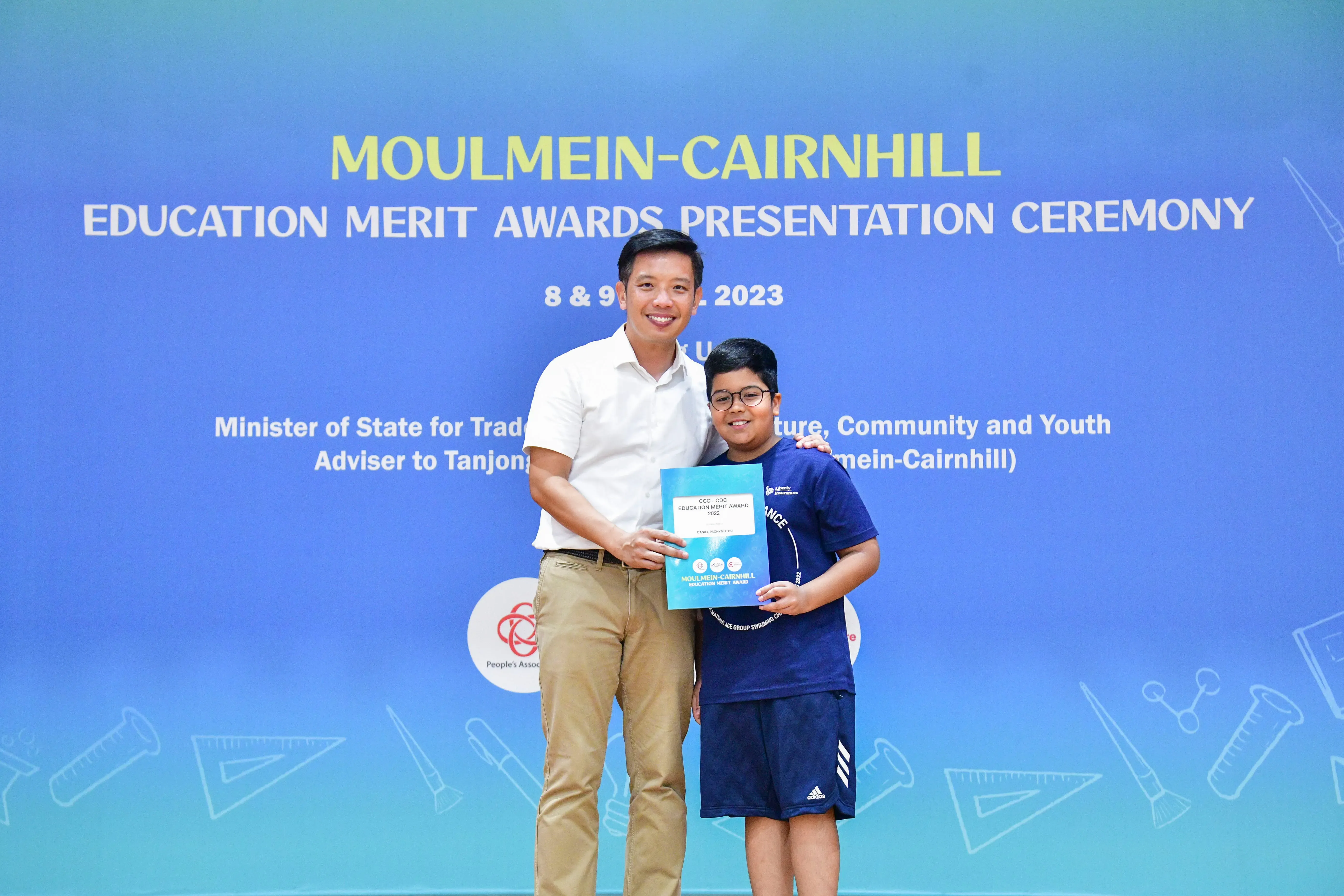 A man and a young boy pose together holding a certificate at the Moulmein-Cairnhill Education Merit Awards 2023.