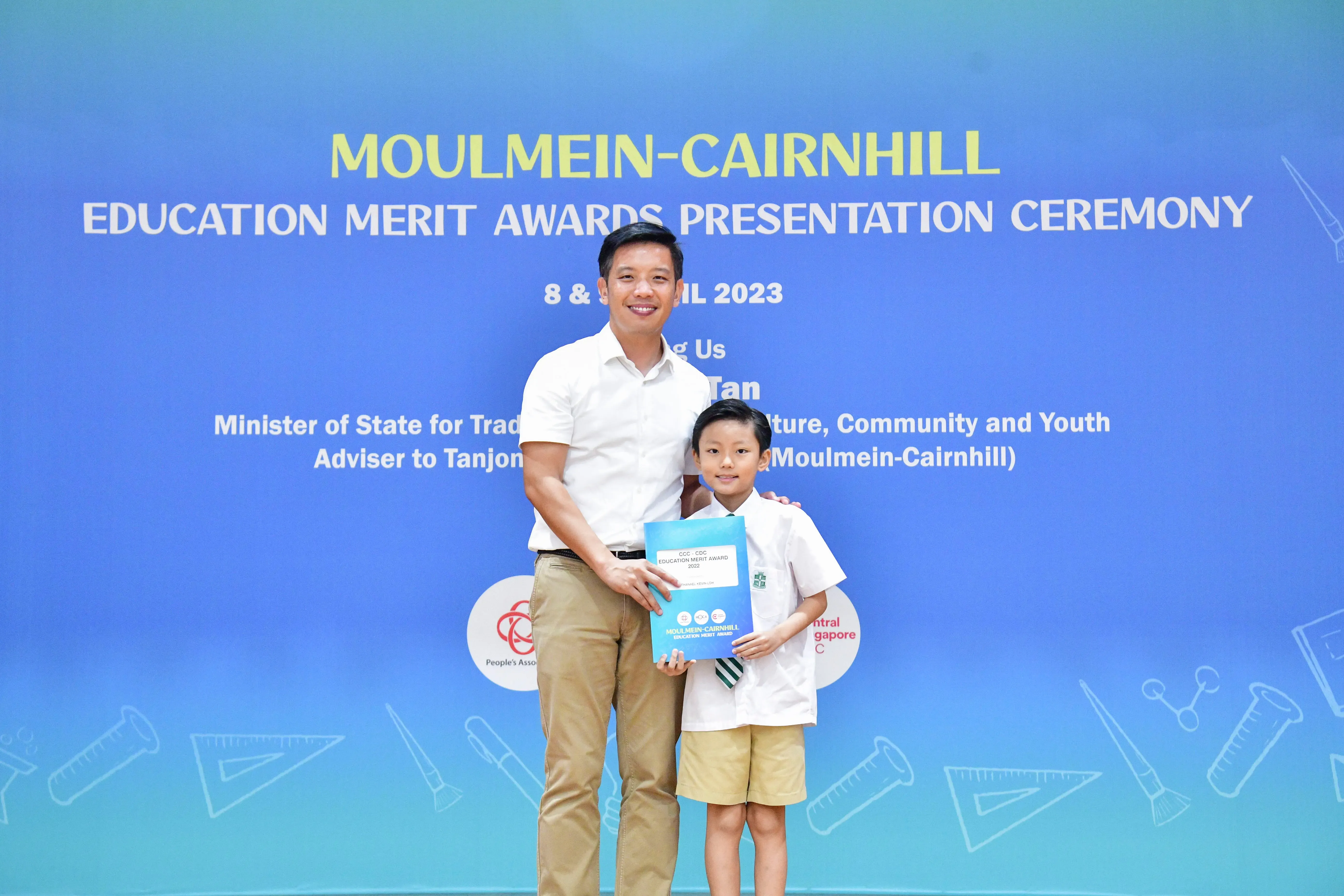 A man and a young boy pose together holding a certificate at the Moulmein-Cairnhill Education Merit Awards 2023.