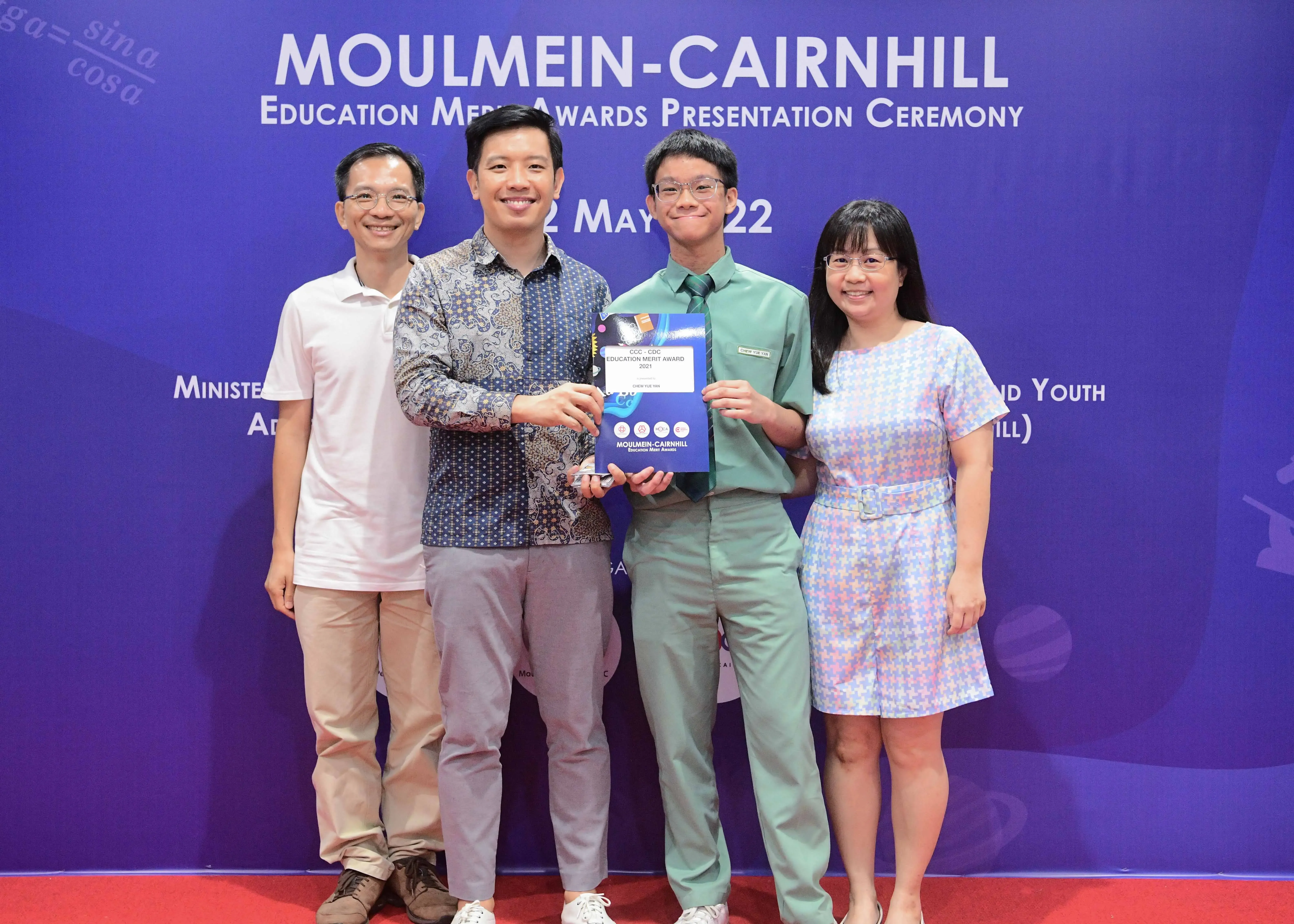 Four people pose together at the Moulmein-Cairnhill Education Merit Awards Ceremony on 2 May 2022.