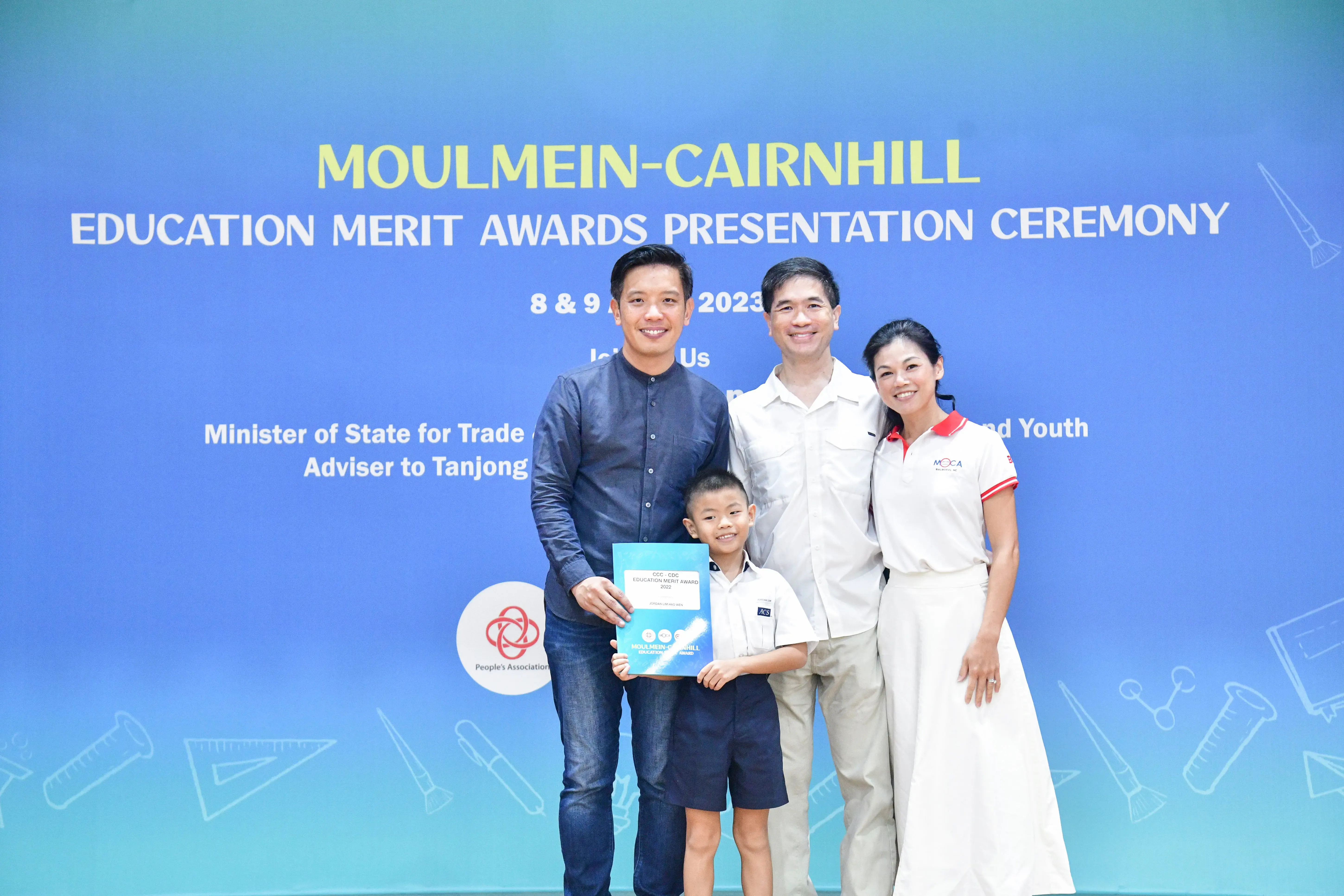 Three adults and a young boy pose with an award certificate at the Moulmein-Cairnhill Education Merit Awards 2023.