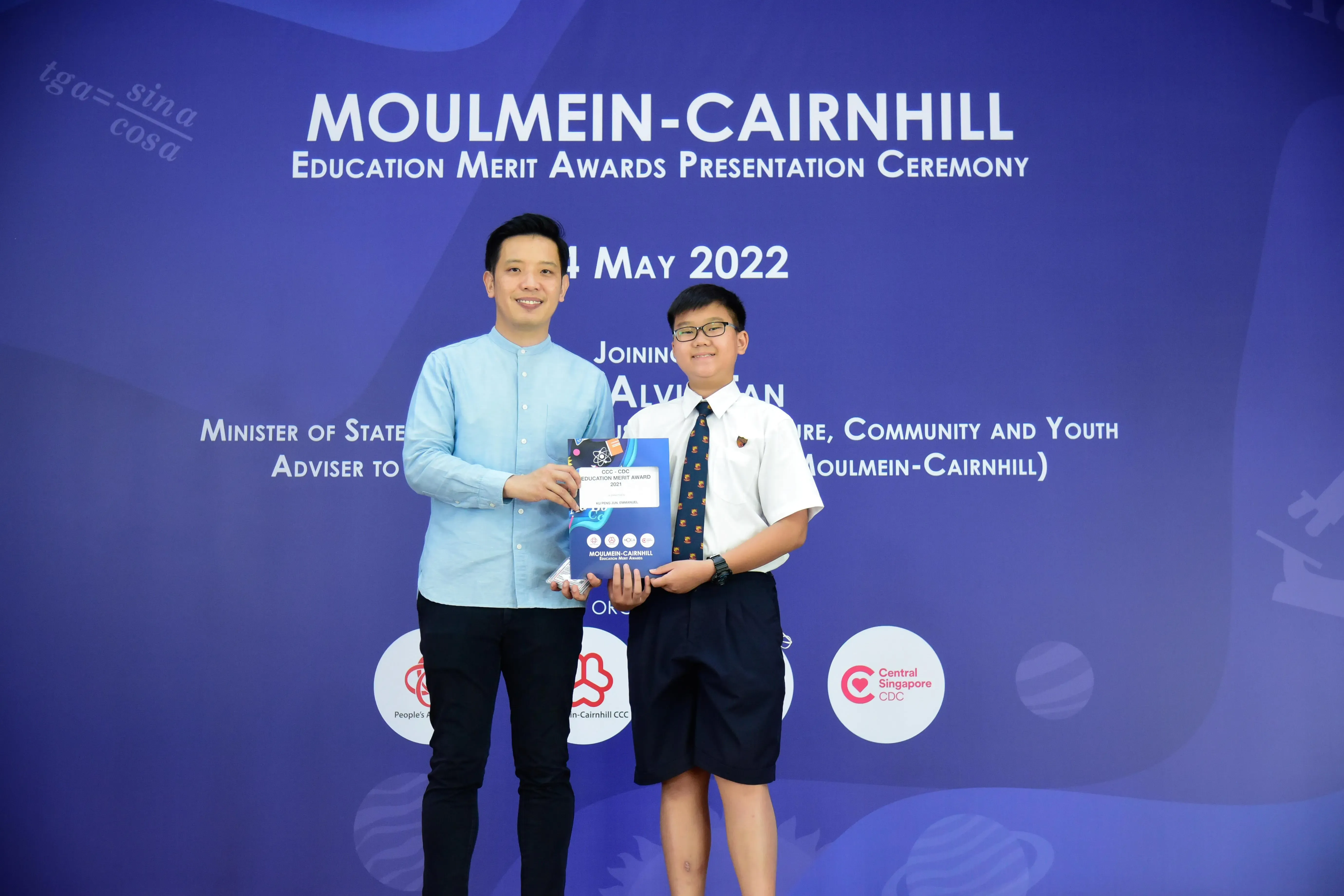 Two people hold an award certificate at the Moulmein-Cairnhill Education Merit Awards Ceremony on 4 May 2022.