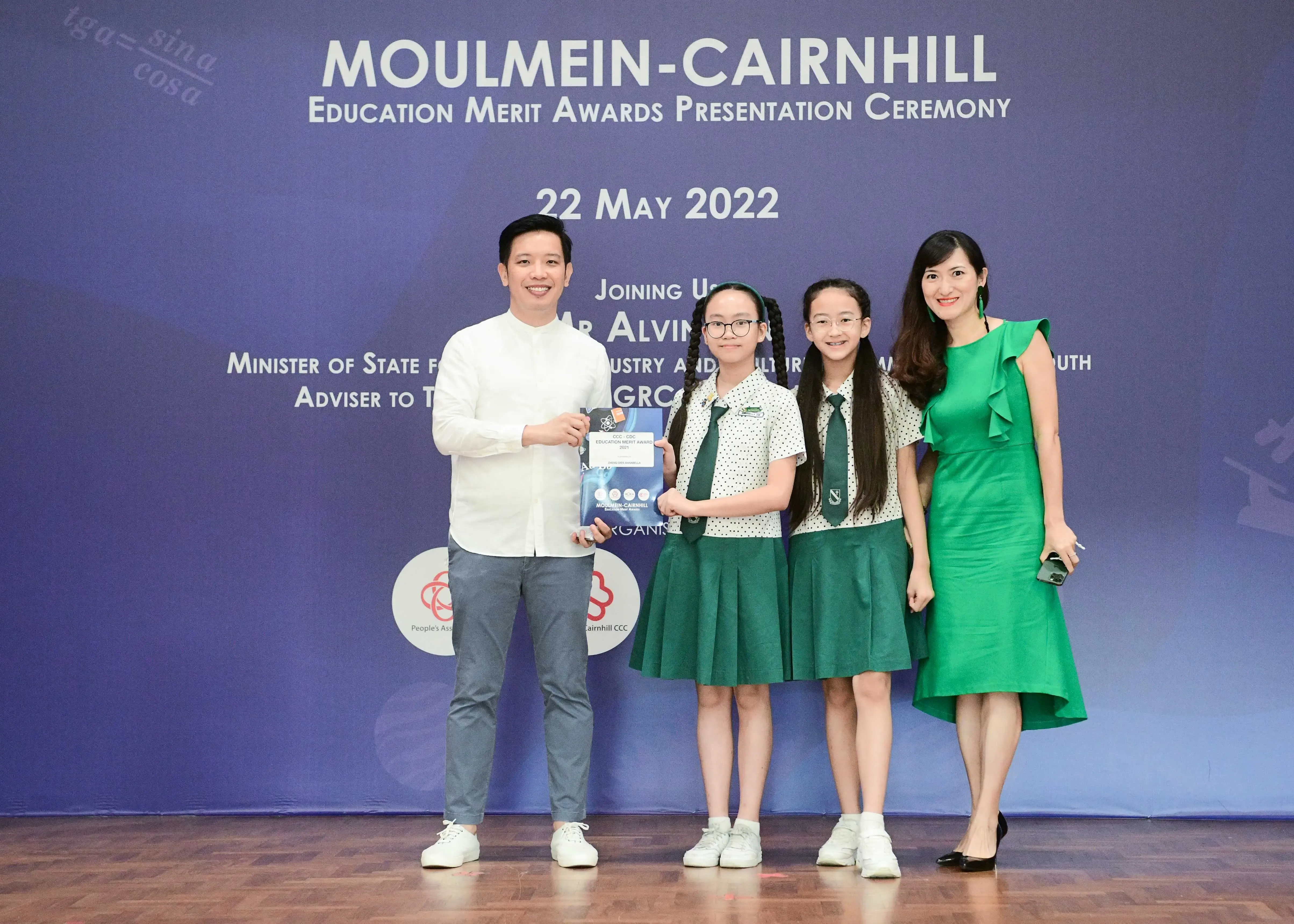 Four people pose on stage at the Moulmein-Cairnhill Education Merit Awards Presentation Ceremony on 22 May 2022.