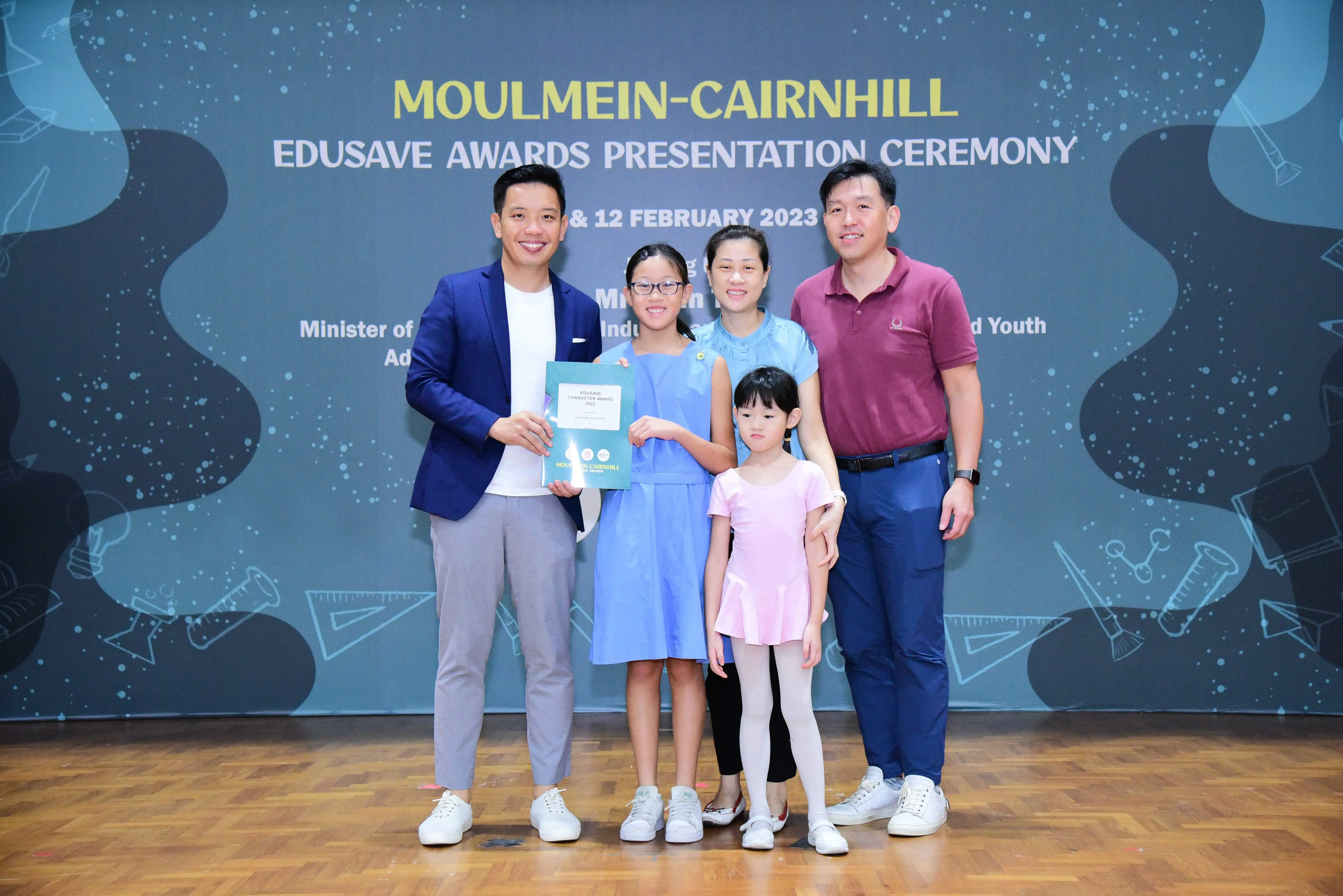 Five people pose with a certificate at the Moulmein-Cairnhill Edusave Awards Presentation Ceremony, February 2023.