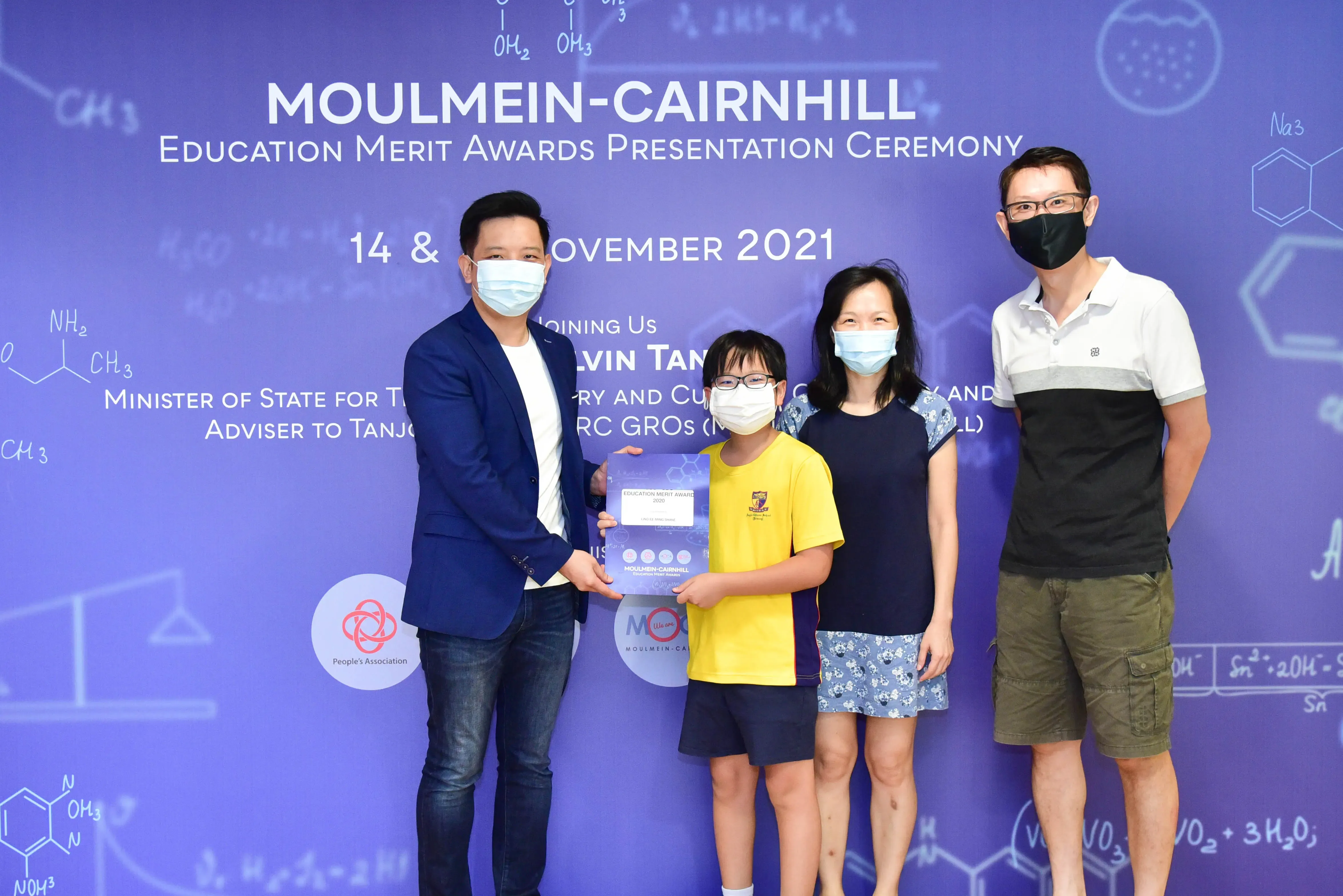 Four masked people pose at the Moulmein-Cairnhill Education Merit Awards Presentation Ceremony in November 2021.