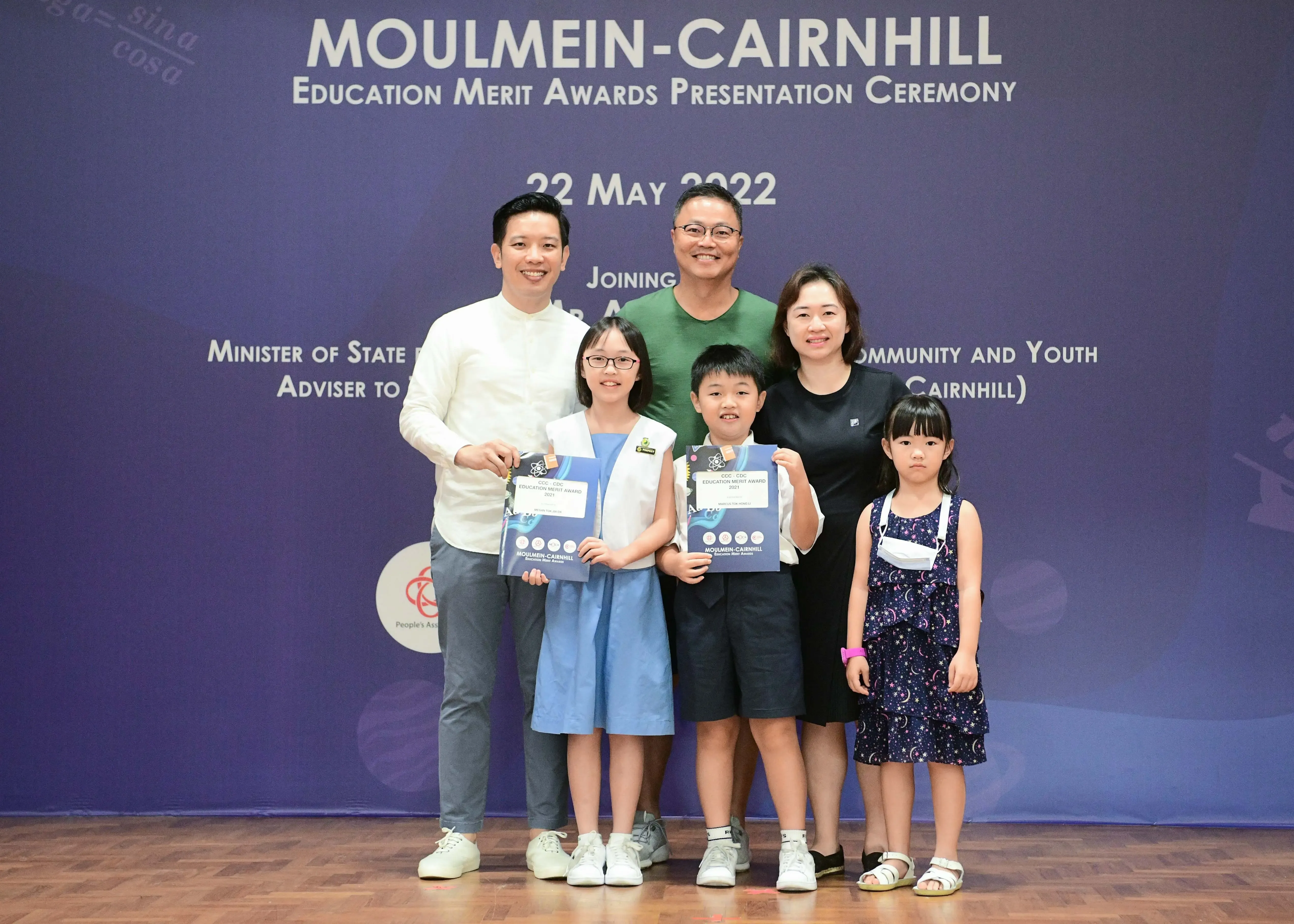 Three adults and three children pose at the Moulmein-Cairnhill Education Merit Awards ceremony on 22 May 2022.