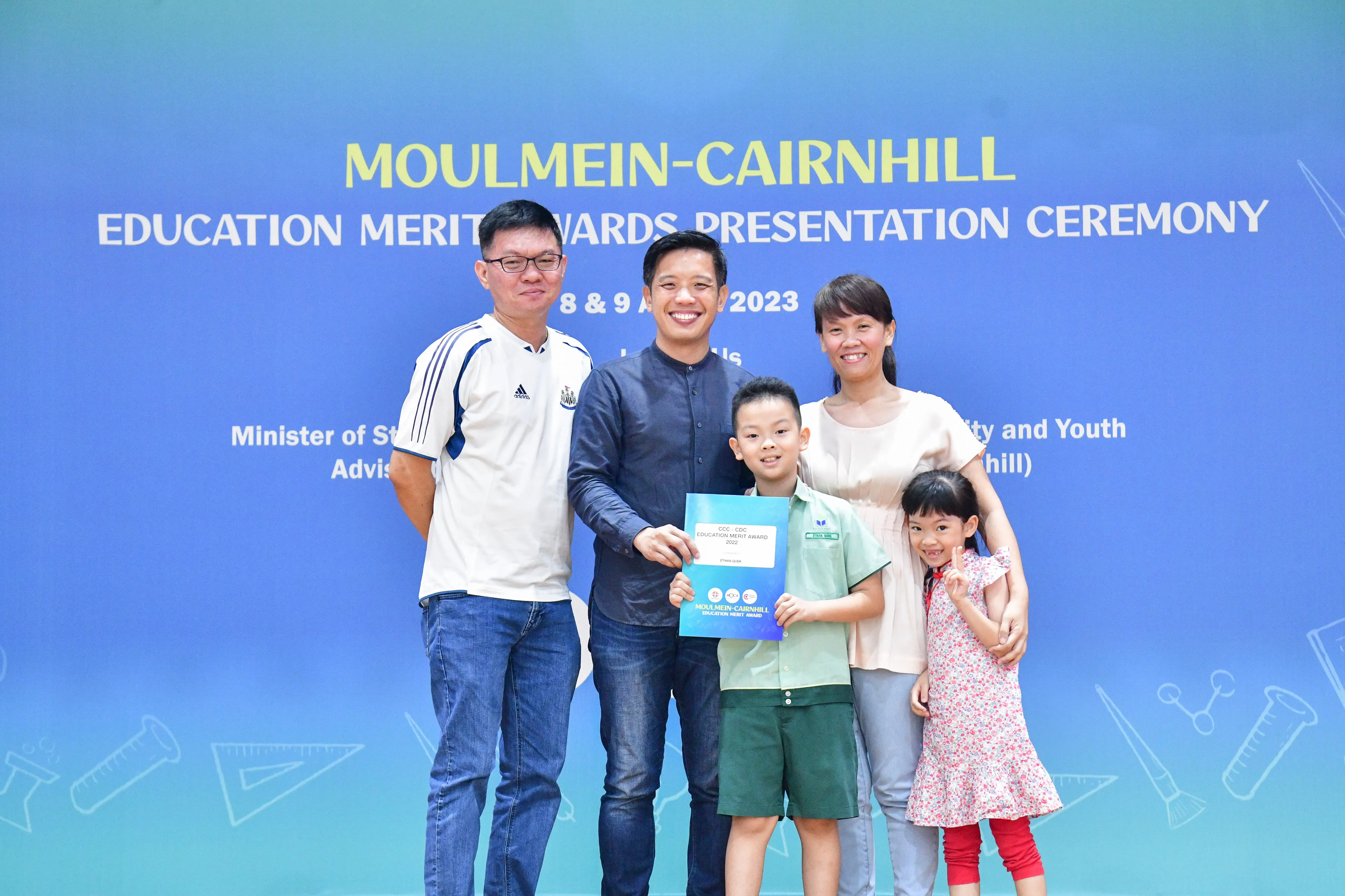 Five people pose with a certificate at the Moulmein-Cairnhill Education Merit Awards Presentation Ceremony 2023.