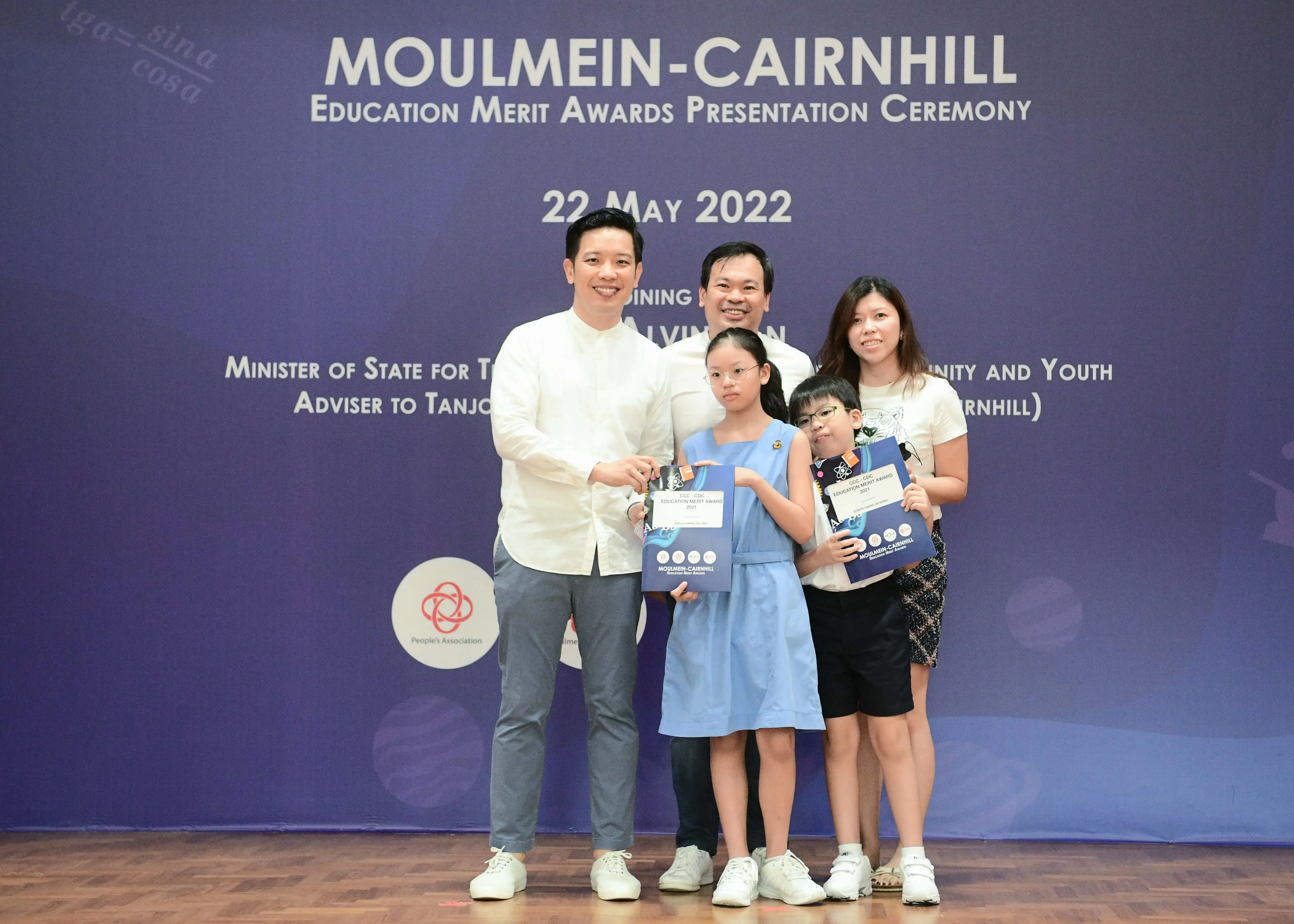 Five people pose with award certificates at the Moulmein-Cairnhill Education Merit Awards Ceremony on 22 May 2022.
