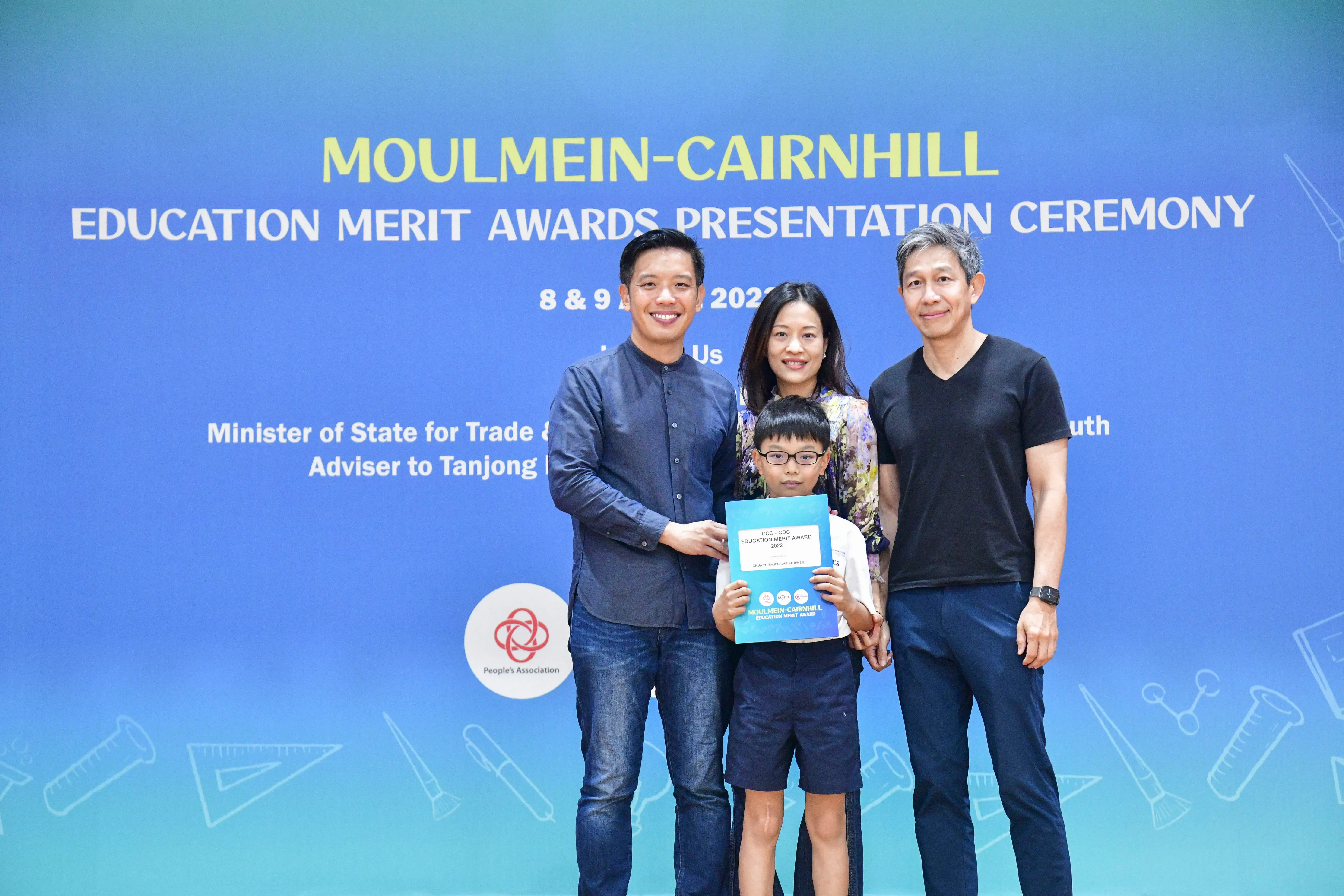 Three adults and a boy holding a certificate pose at the Moulmein-Cairnhill Education Merit Awards Presentation Ceremony.
