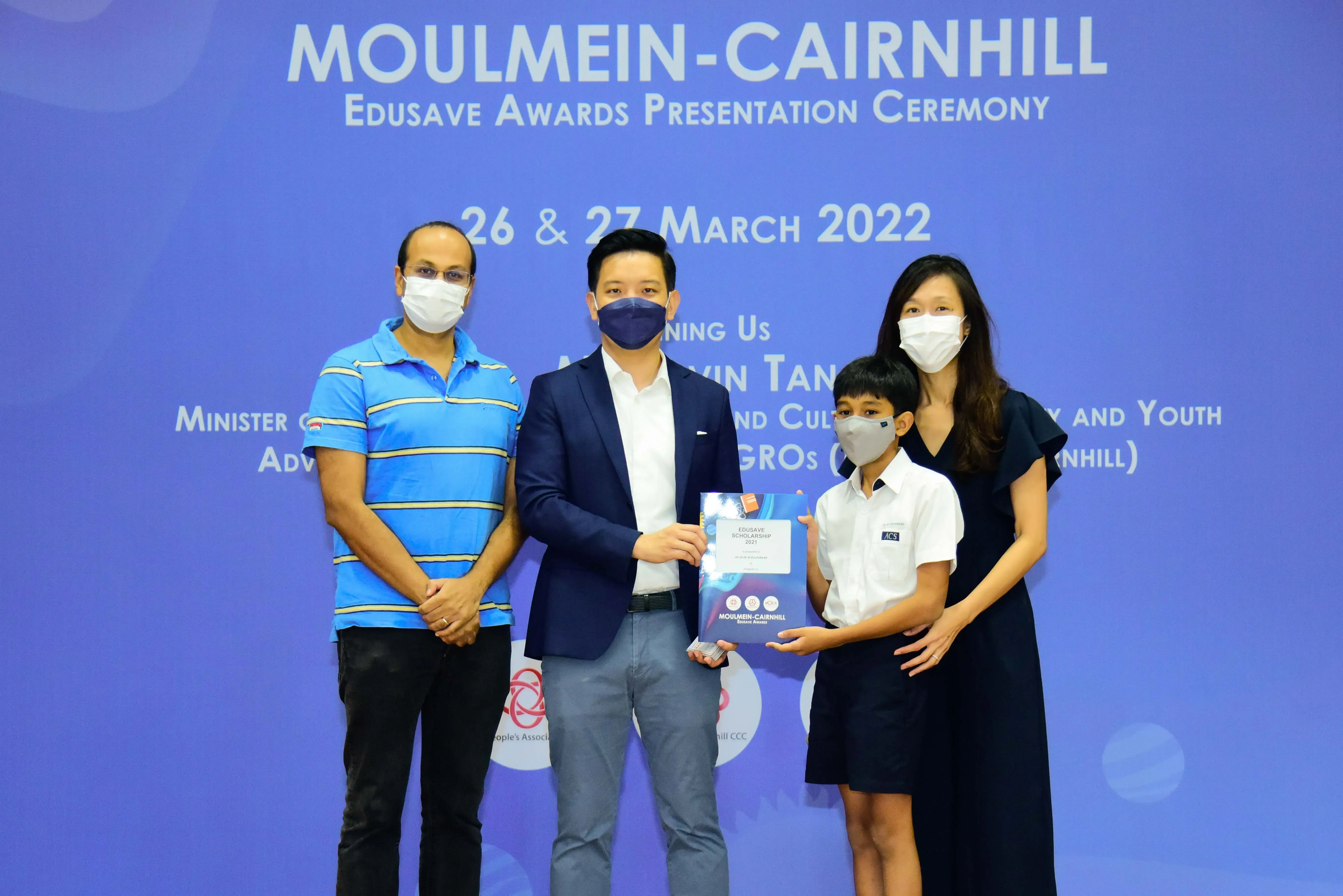 Four masked people pose at the Moulmein-Cairnhill Edusave Awards Presentation Ceremony on 26-27 March 2022.