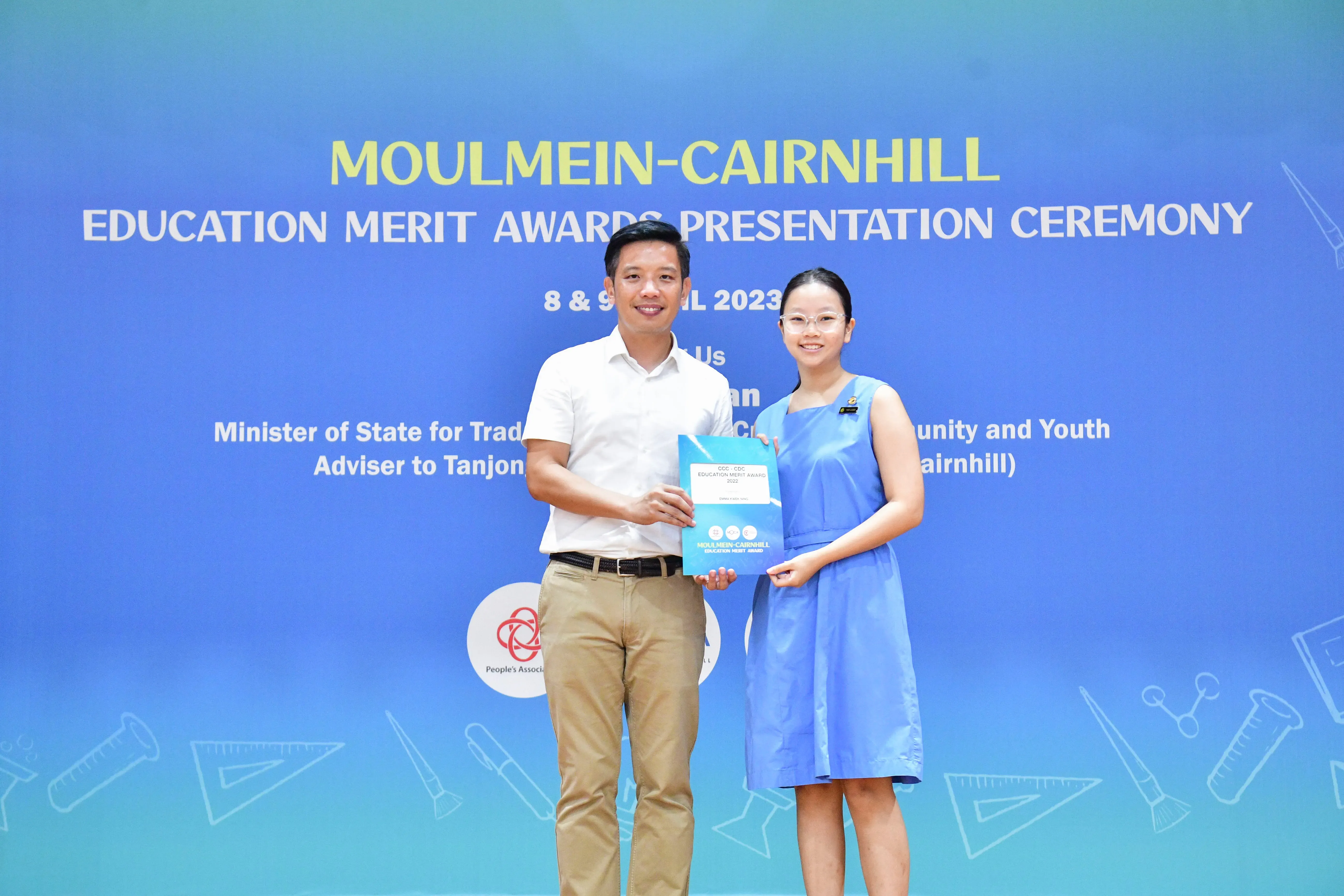 Two people hold an award certificate at the Moulmein-Cairnhill Education Merit Awards Presentation Ceremony 2023.