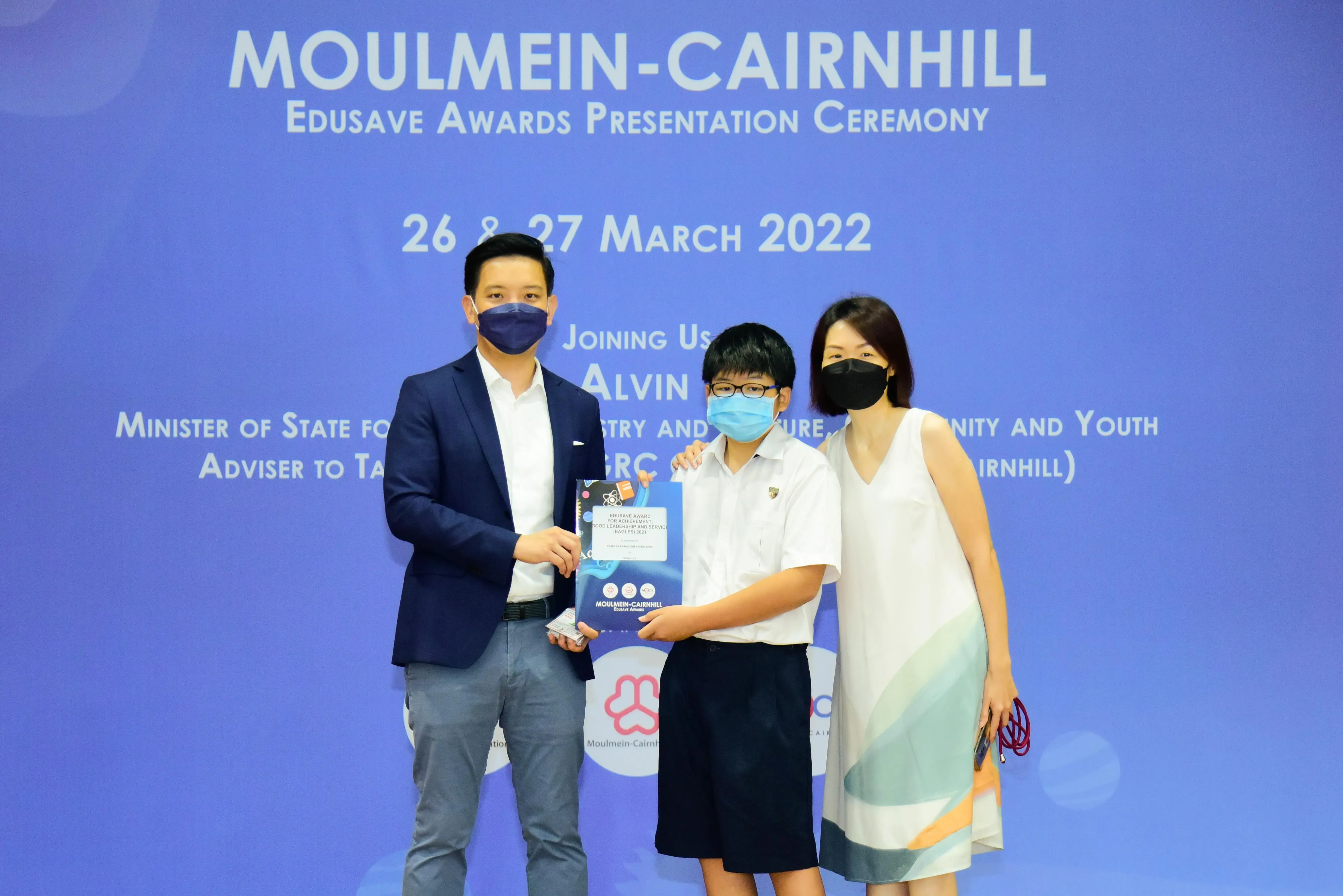 Three masked people pose at the Moulmein-Cairnhill Edusave Awards Presentation Ceremony on 26-27 March 2022.