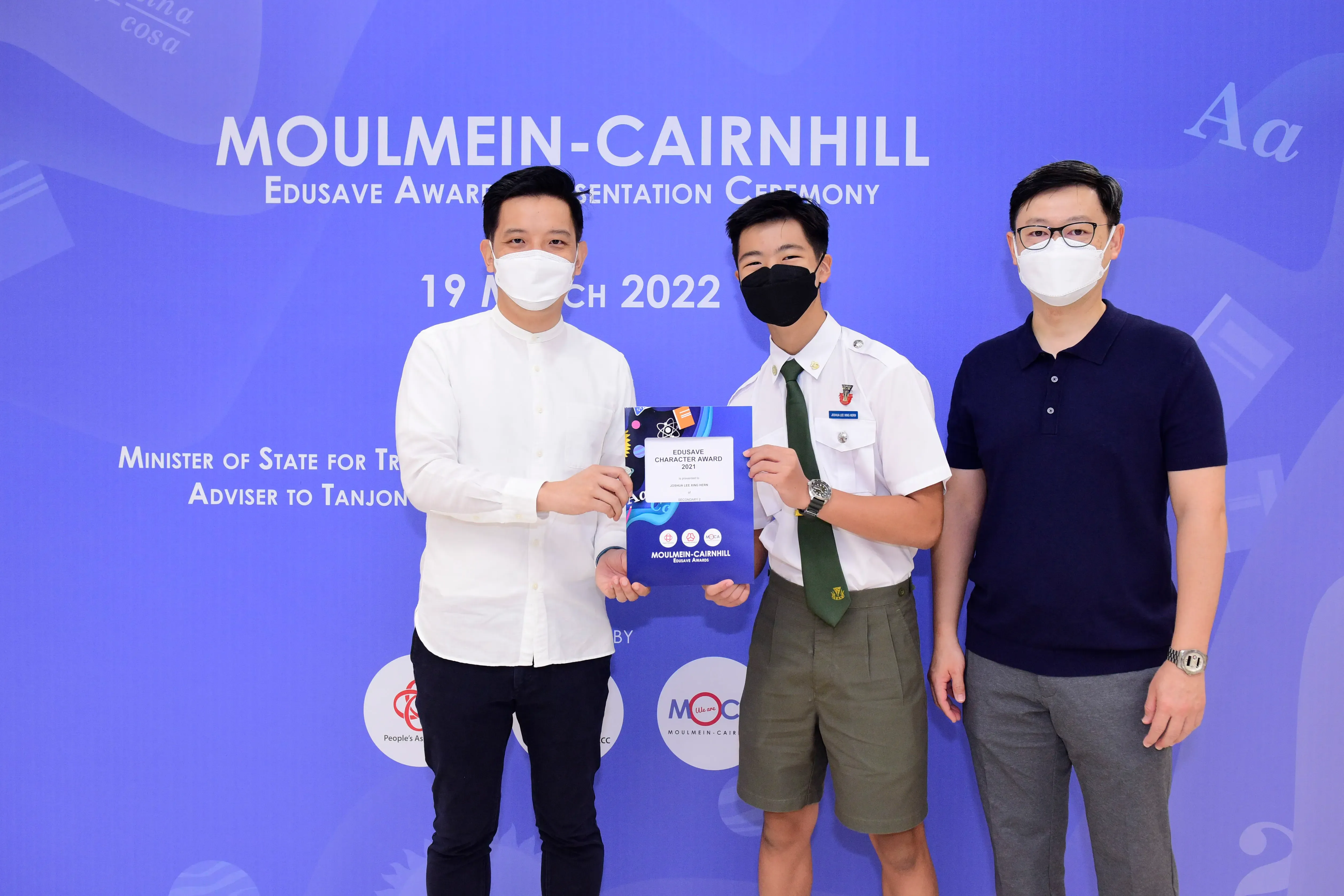 Three masked men pose at the Moulmein-Cairnhill Edusave Award Presentation Ceremony on 19 March 2022.