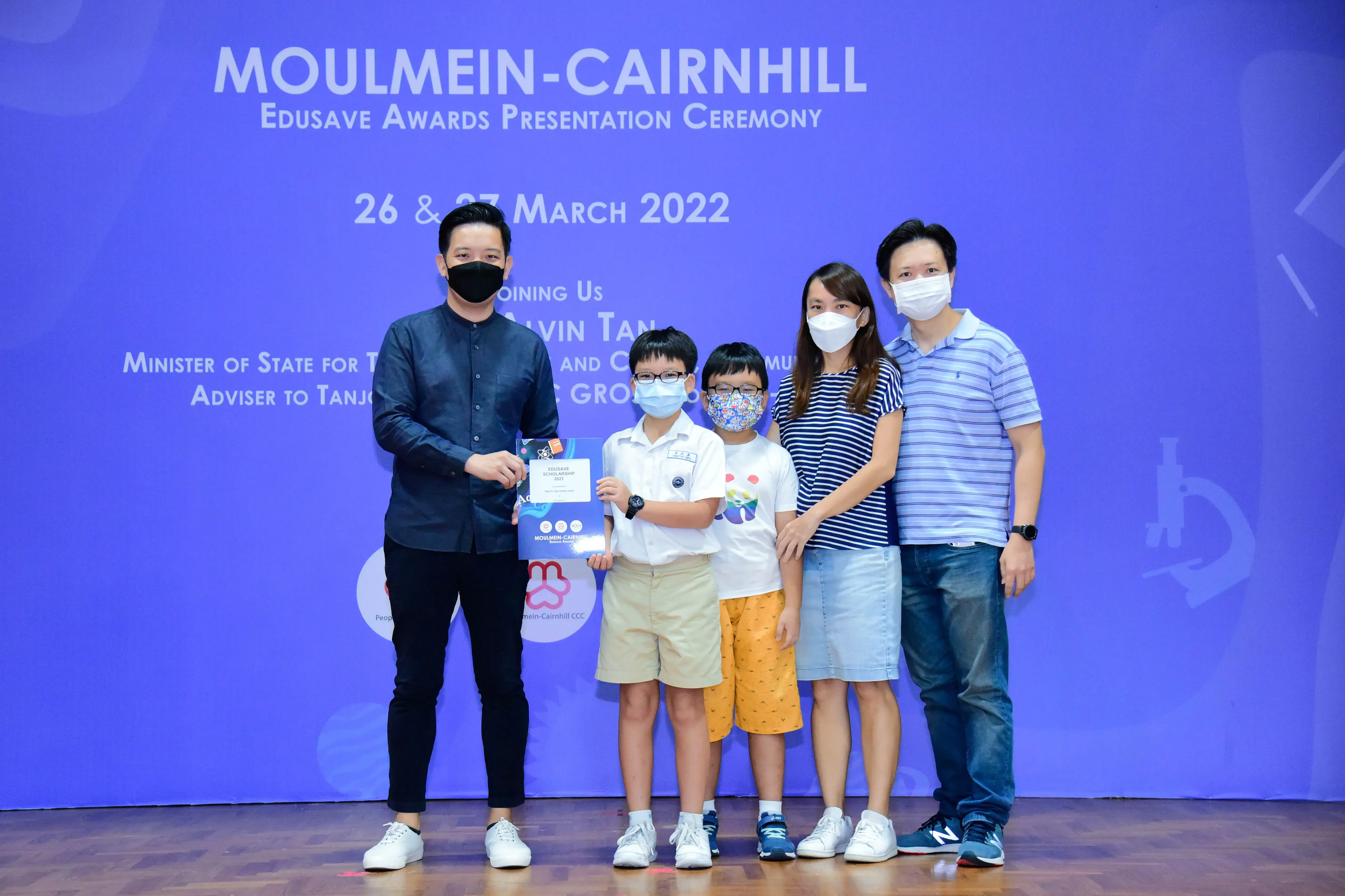 Five masked people pose at the Moulmein-Cairnhill Edusave Awards Presentation Ceremony on 26-27 March 2022.