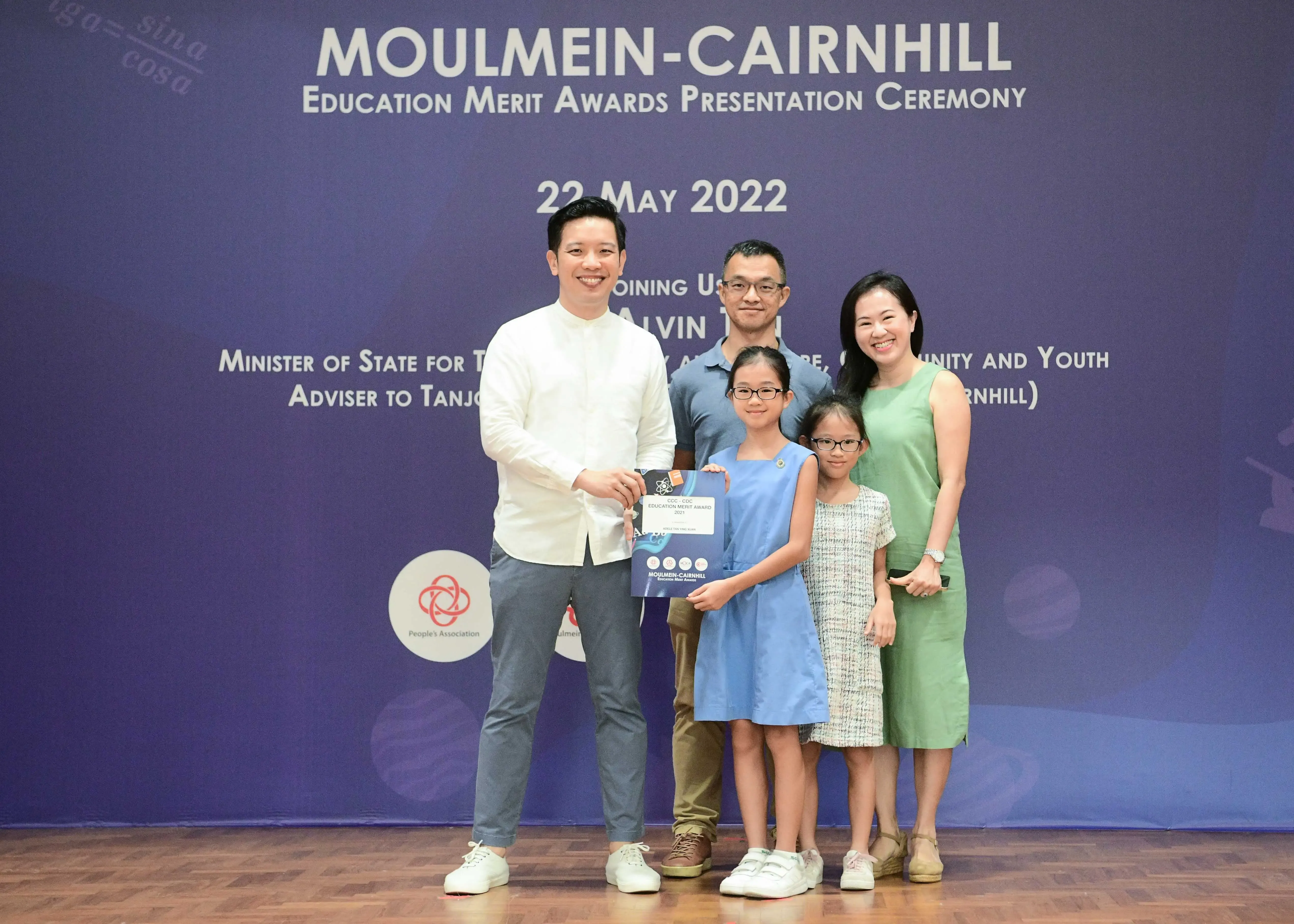 Five people pose with an award certificate at the Moulmein-Cairnhill Education Merit Awards Ceremony on 22 May 2022.
