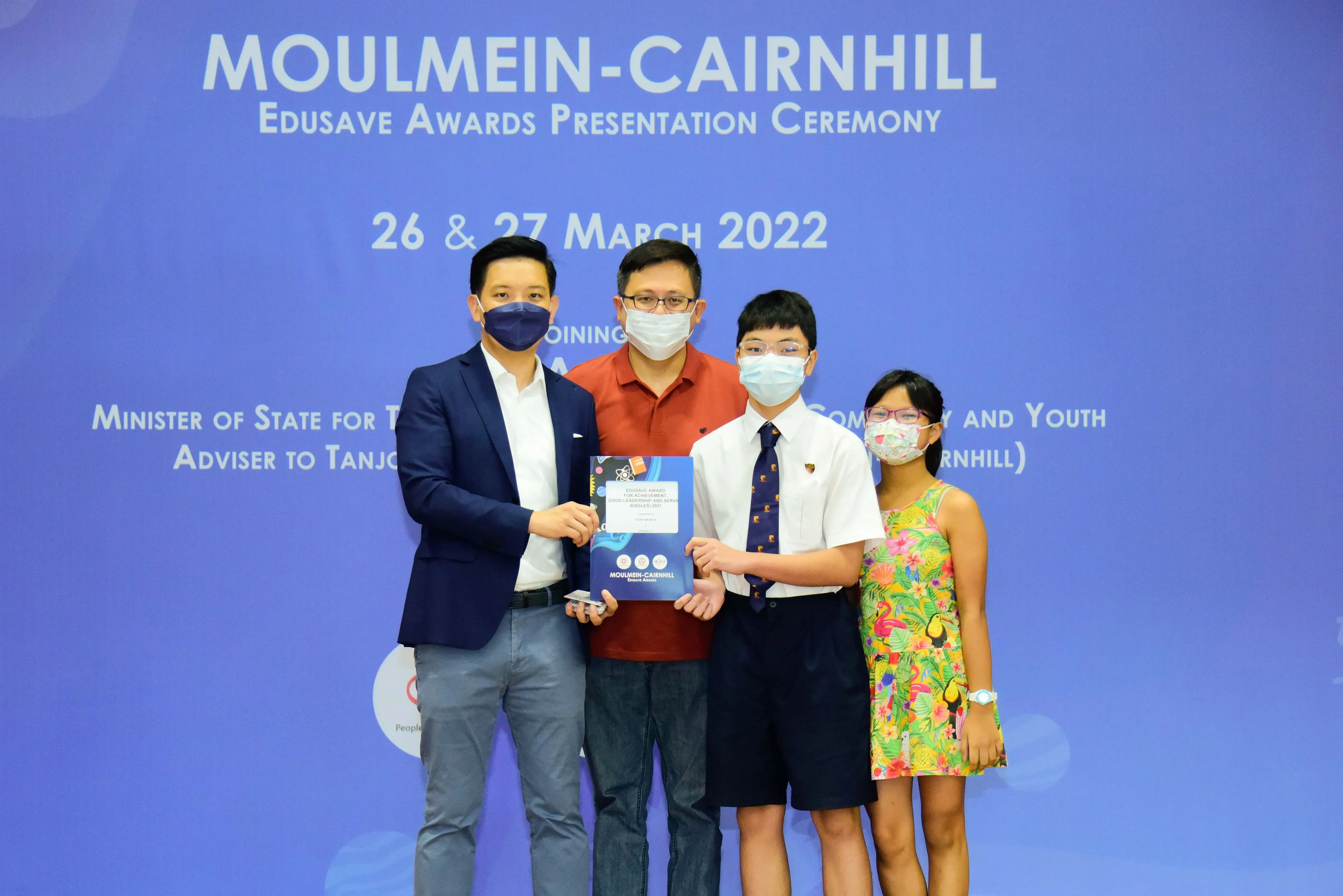 Four masked people pose at the Moulmein-Cairnhill Edusave Awards Presentation Ceremony on 26 and 27 March 2022.