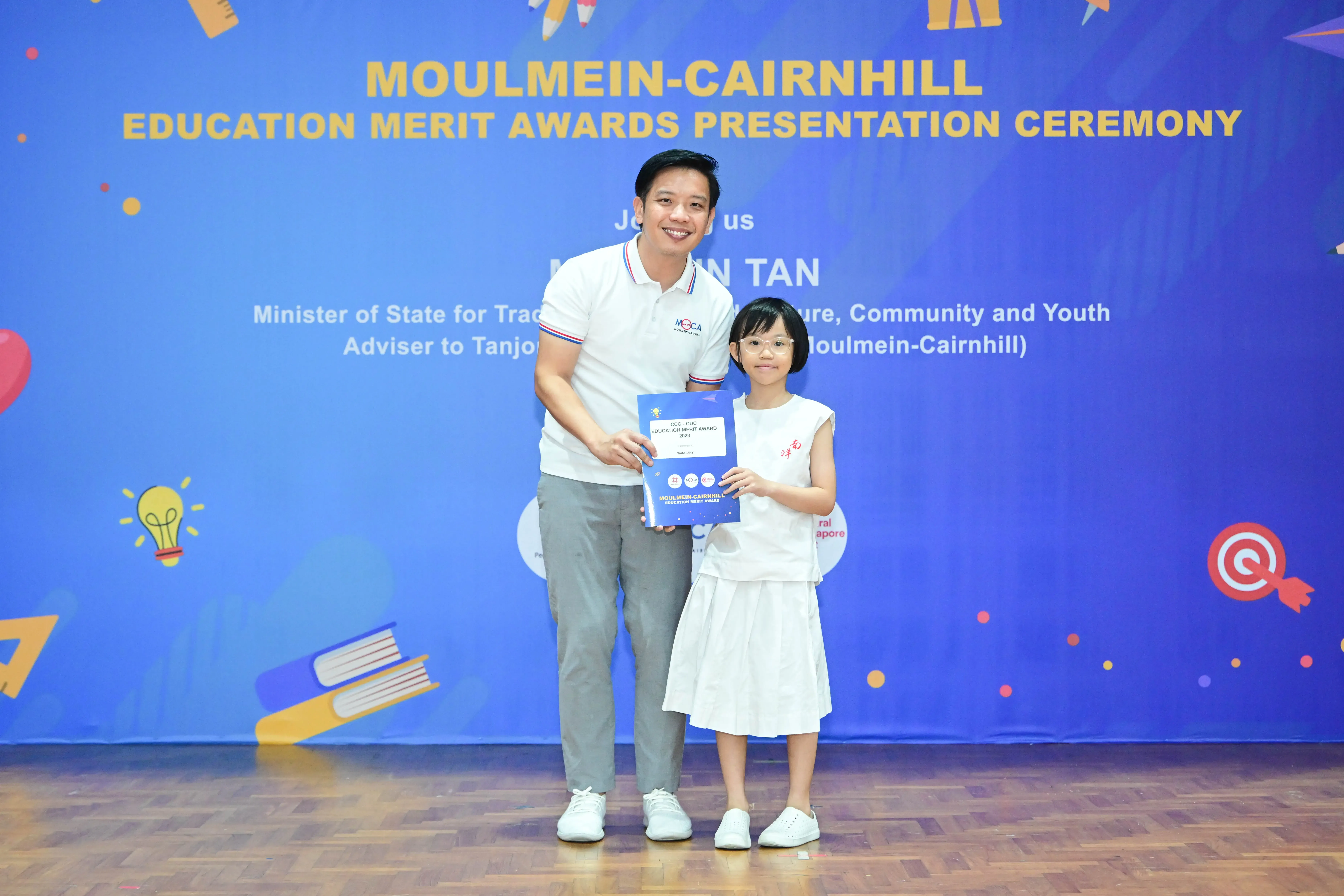 Man and young girl holding a certificate at Moulmein-Cairnhill Education Merit Awards Presentation Ceremony.