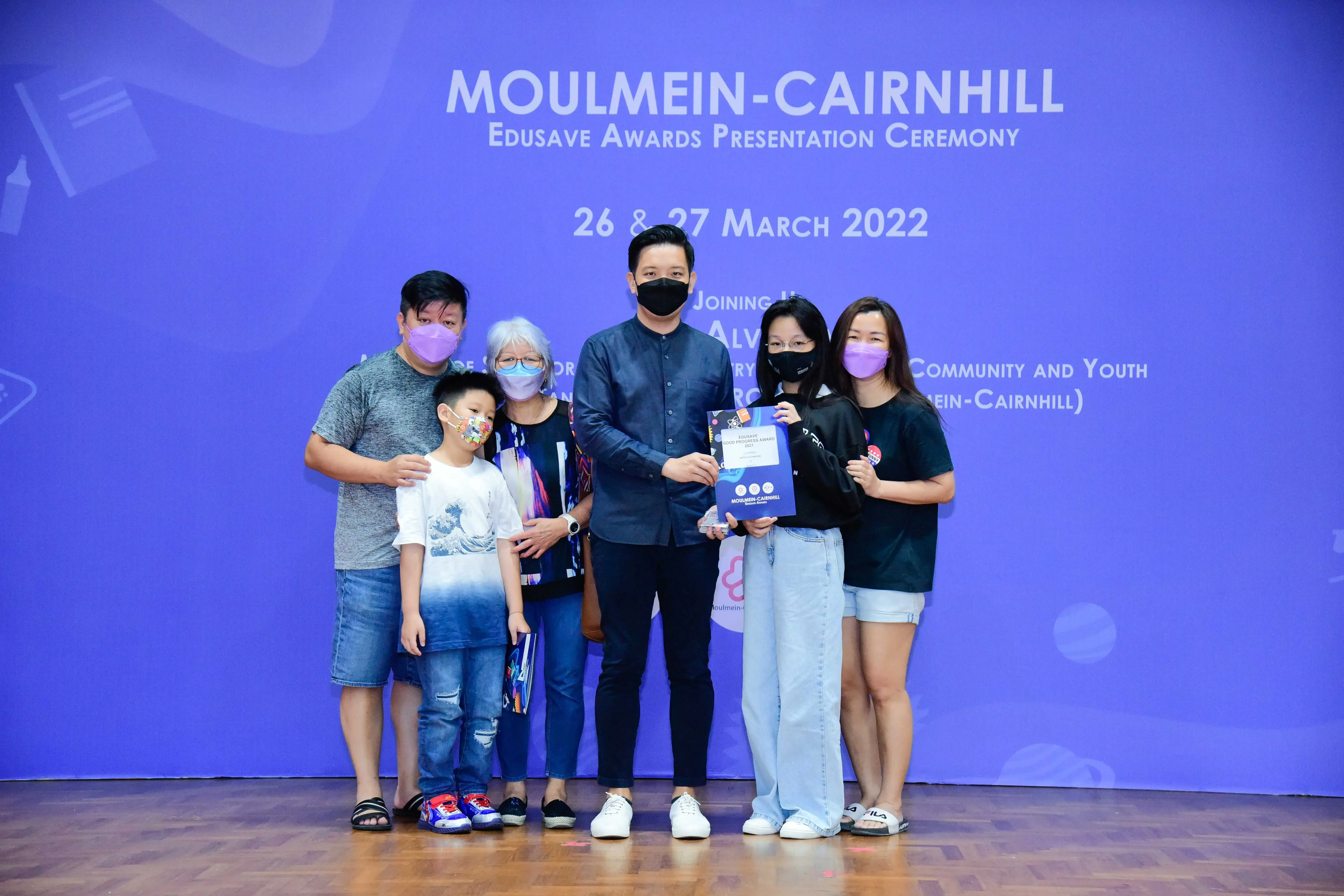 Six masked people pose at the Moulmein-Cairnhill Edusave Awards Presentation Ceremony on 26-27 March 2022.