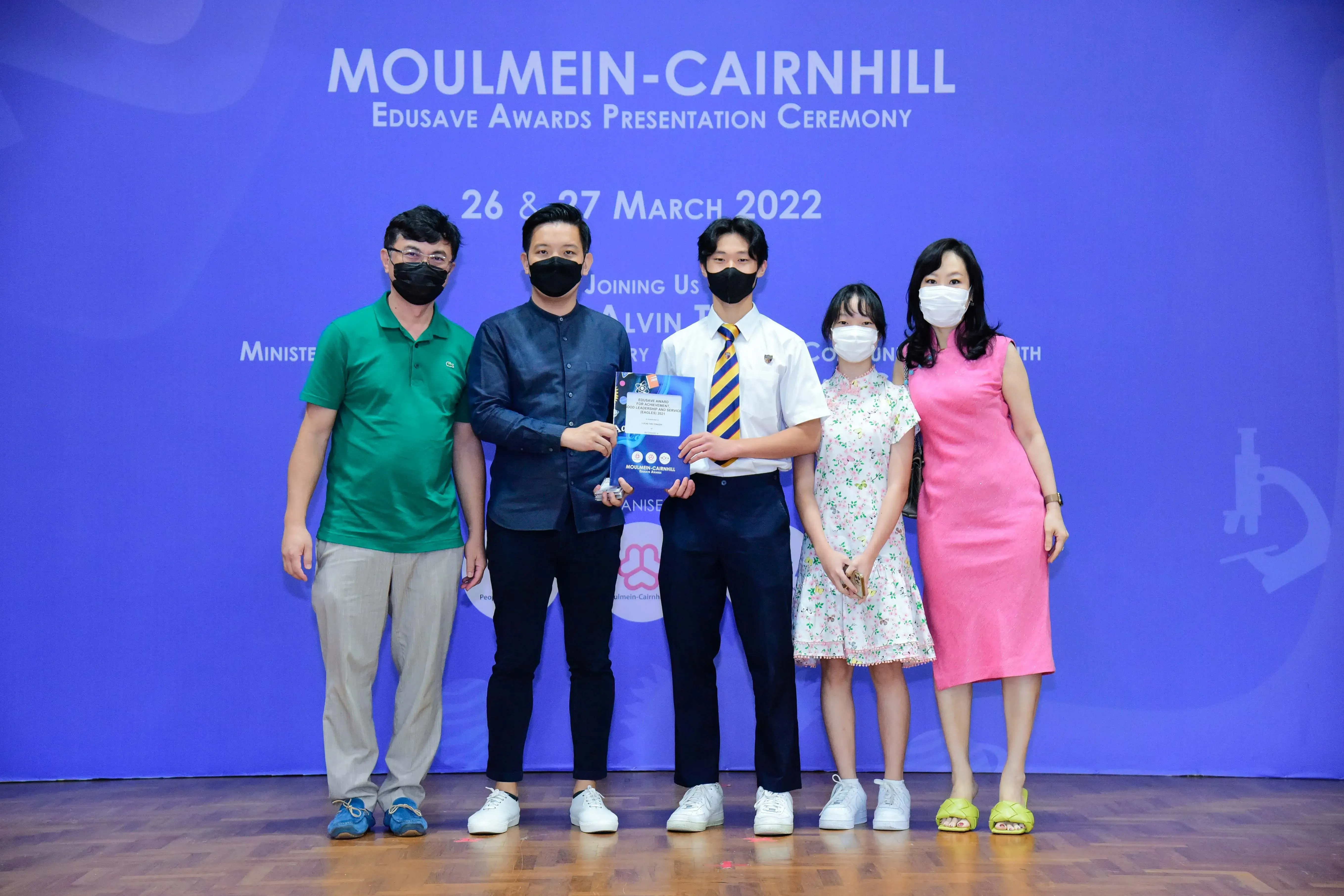 Five masked people pose at the Moulmein-Cairnhill Edusave Awards Presentation Ceremony on 26-27 March 2022.