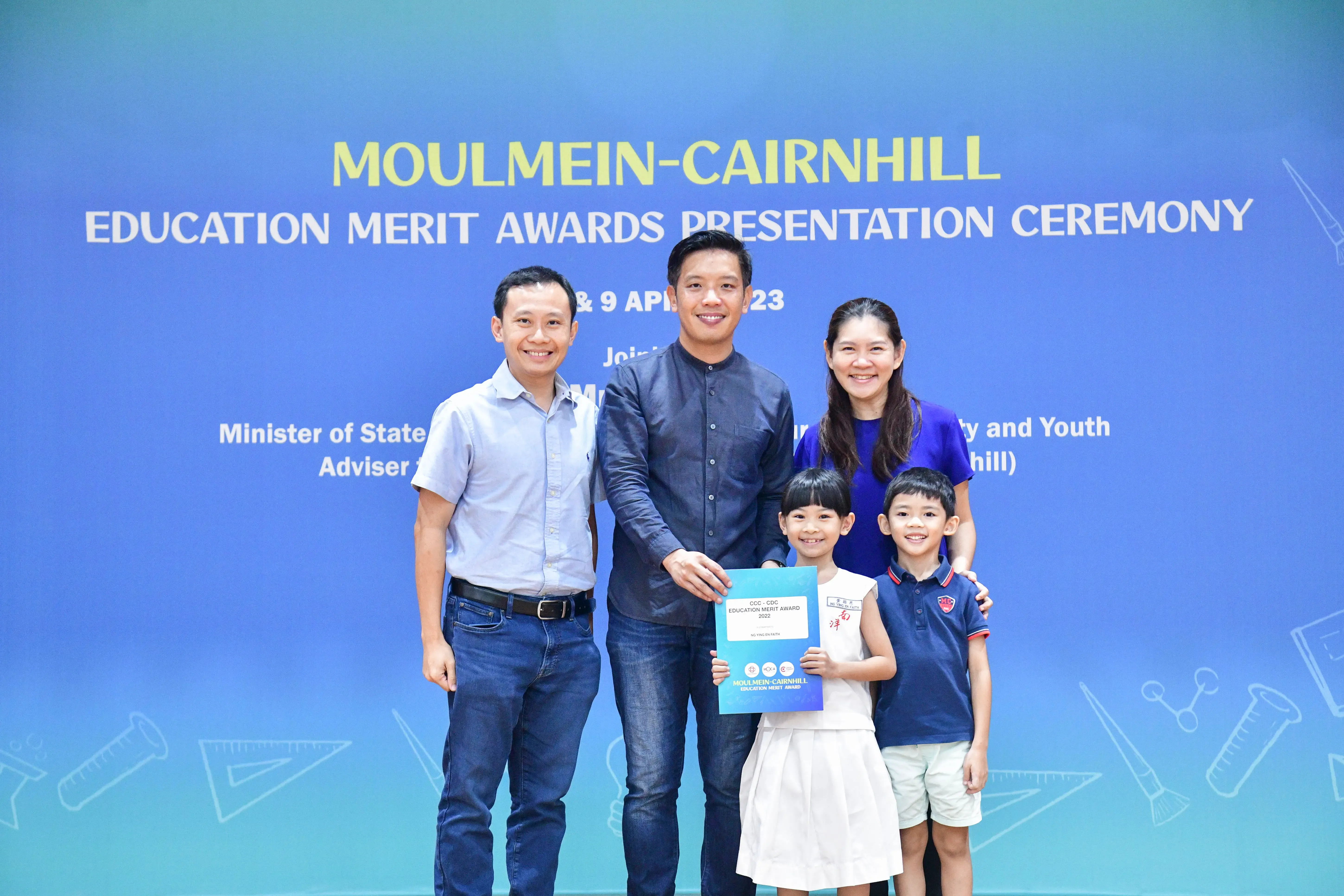 Three adults and two children pose at the Moulmein-Cairnhill Education Merit Awards Presentation Ceremony.