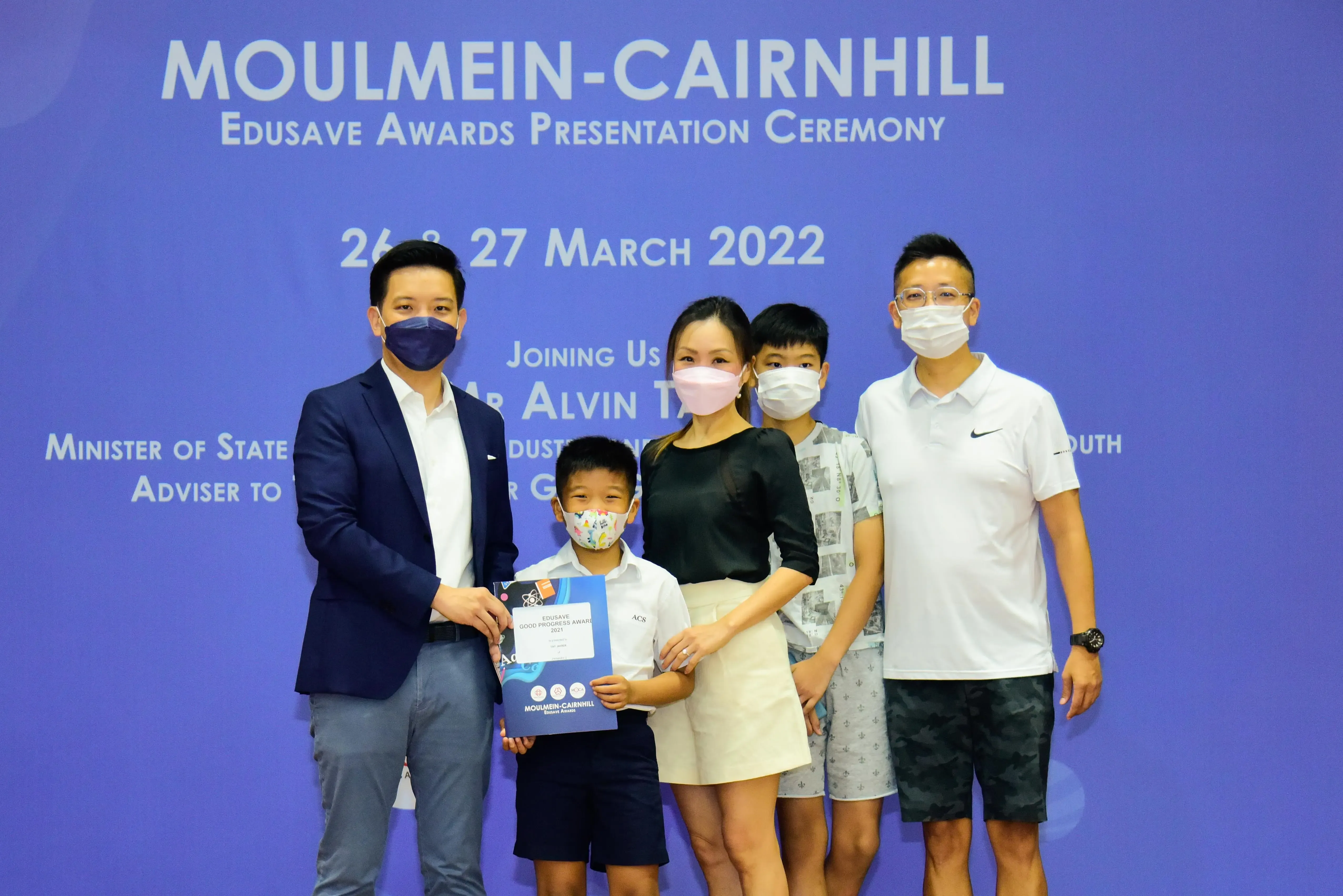 Five masked people pose at the Moulmein-Cairnhill Edusave Awards Presentation Ceremony on 26-27 March 2022.