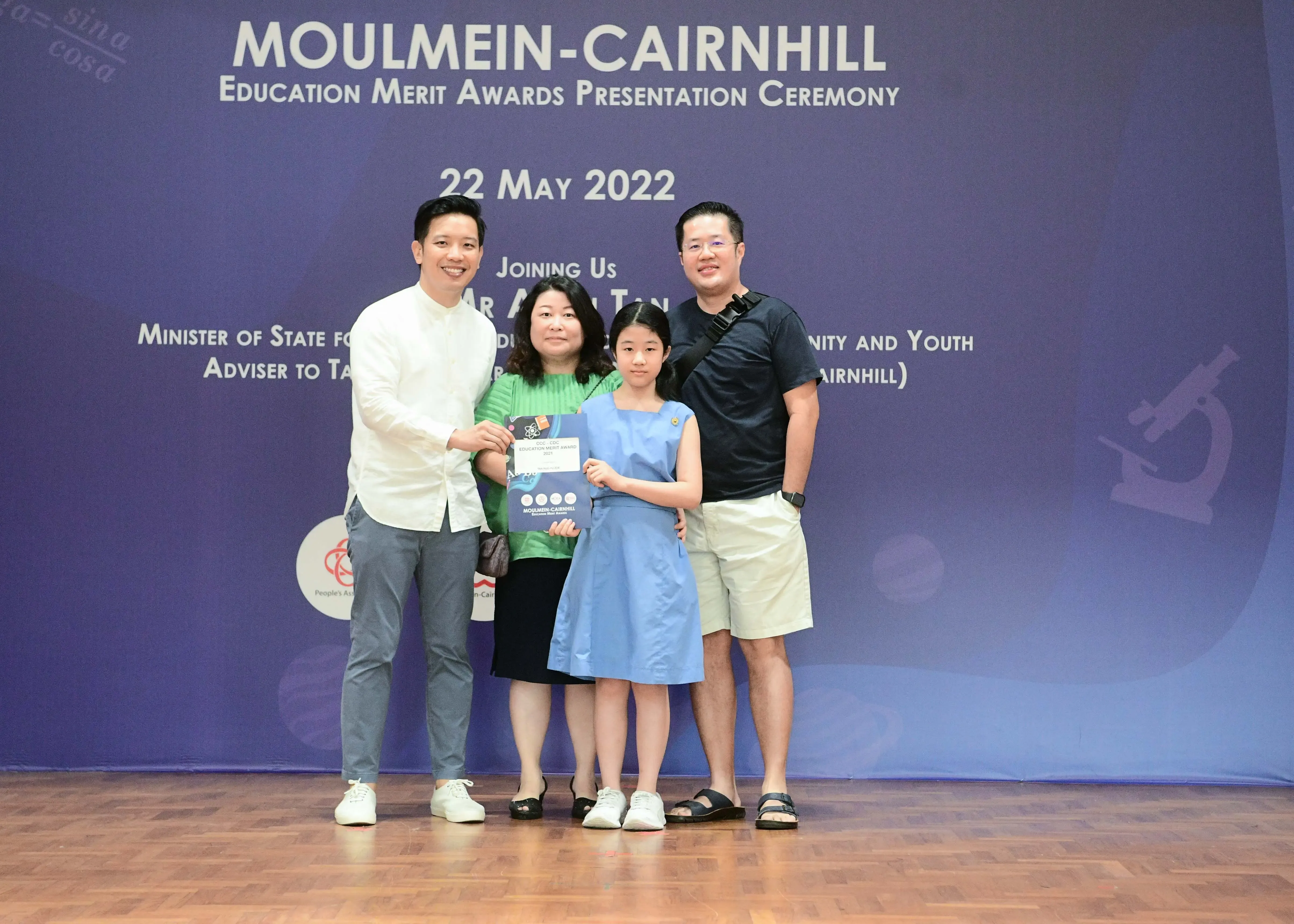 Four people pose with an award certificate at the Moulmein-Cairnhill Education Merit Awards Ceremony on 22 May 2022.