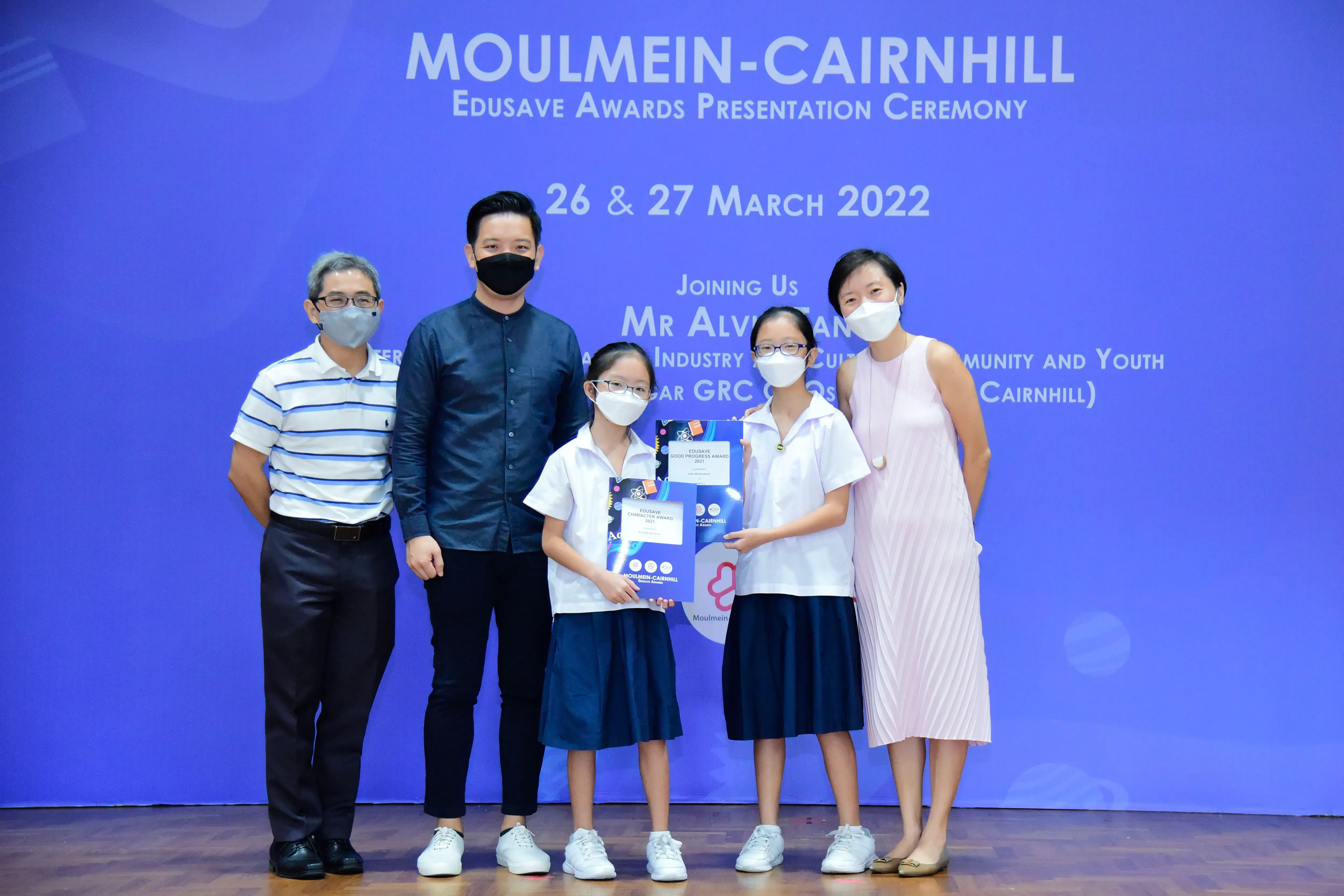 Five masked people pose at the Moulmein-Cairnhill Edusave Awards Presentation Ceremony on 26-27 March 2022.