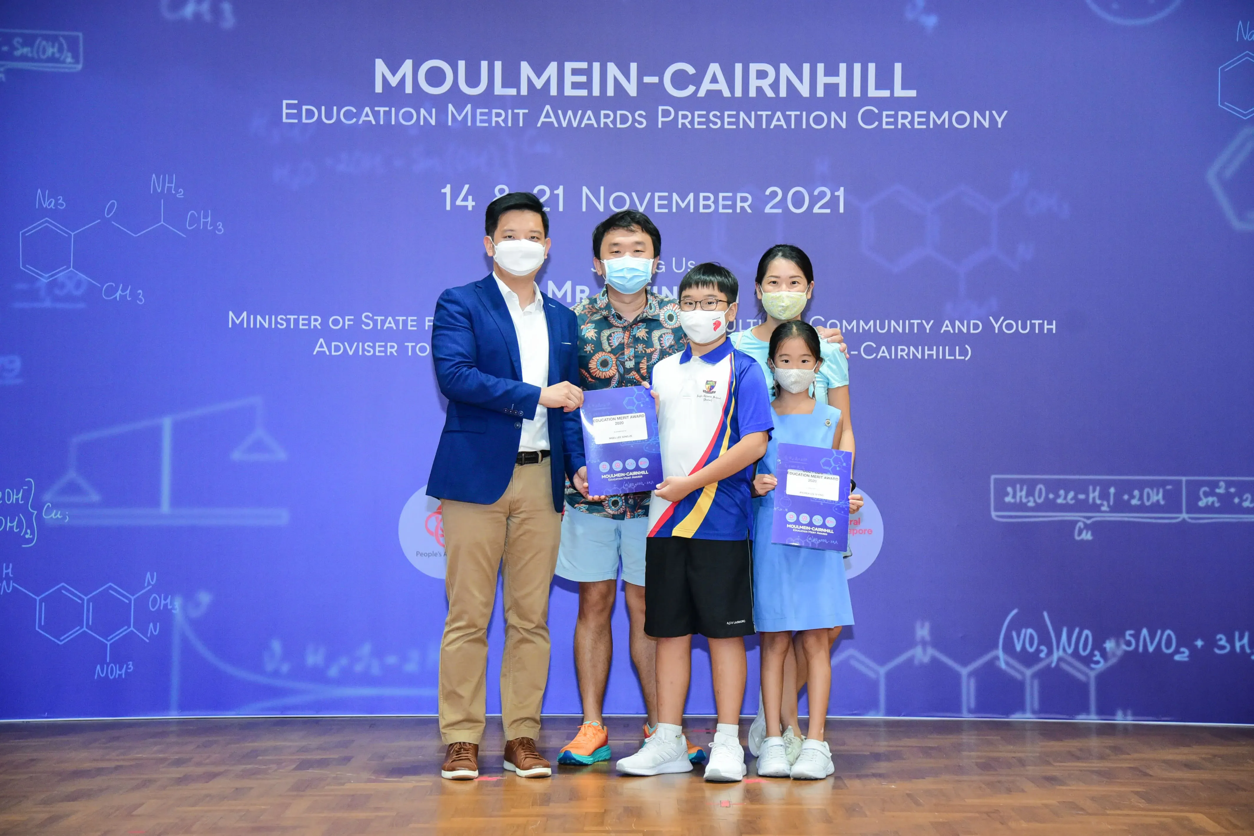 Five masked people pose at the Moulmein-Cairnhill Education Merit Awards Presentation Ceremony on 14-21 November 2021.