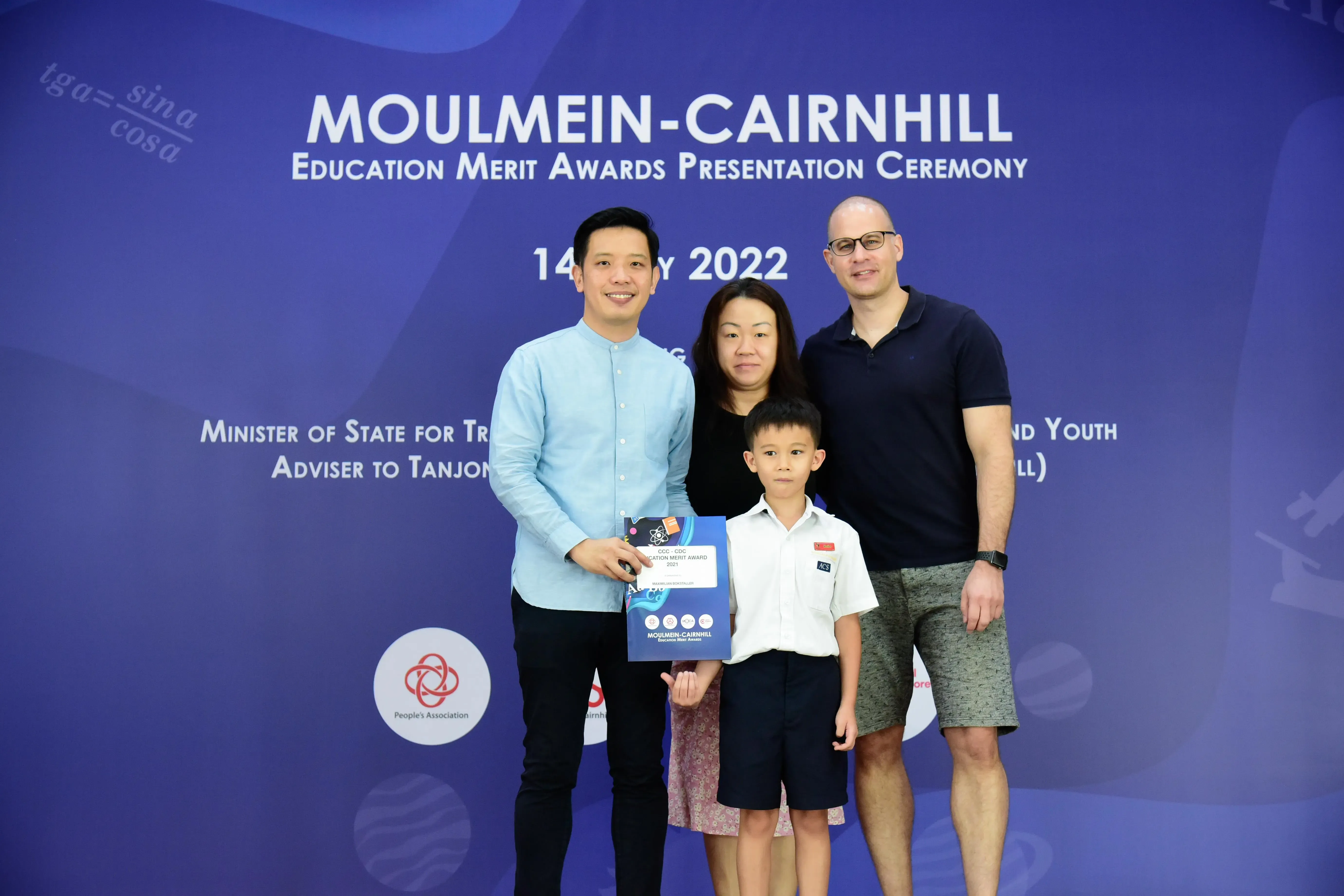 Four people pose at the Moulmein-Cairnhill Education Merit Awards Presentation Ceremony 2022, holding an award.