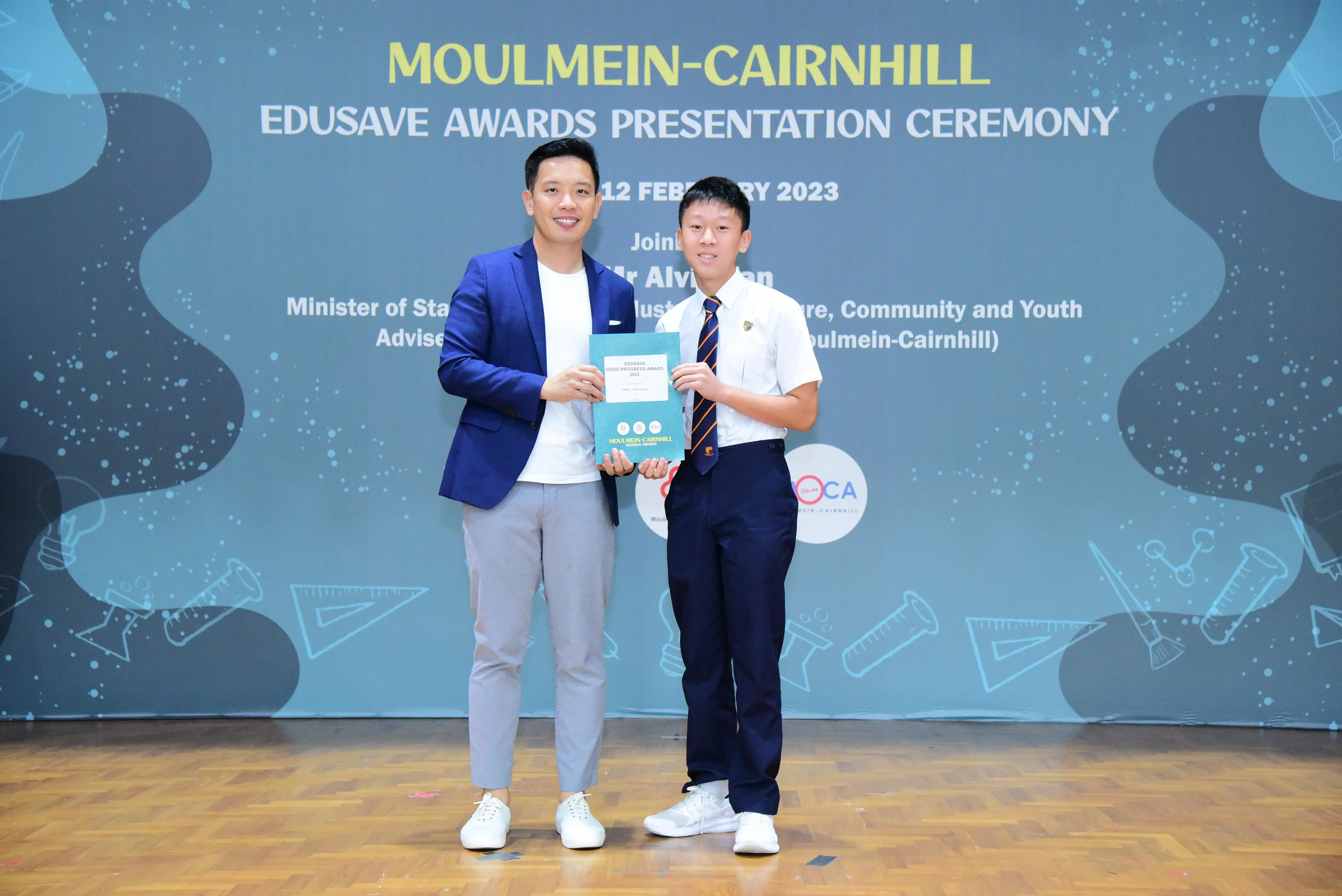 Two people hold an award certificate at the Moulmein-Cairnhill Edusave Awards Presentation Ceremony on 12 February 2023.
