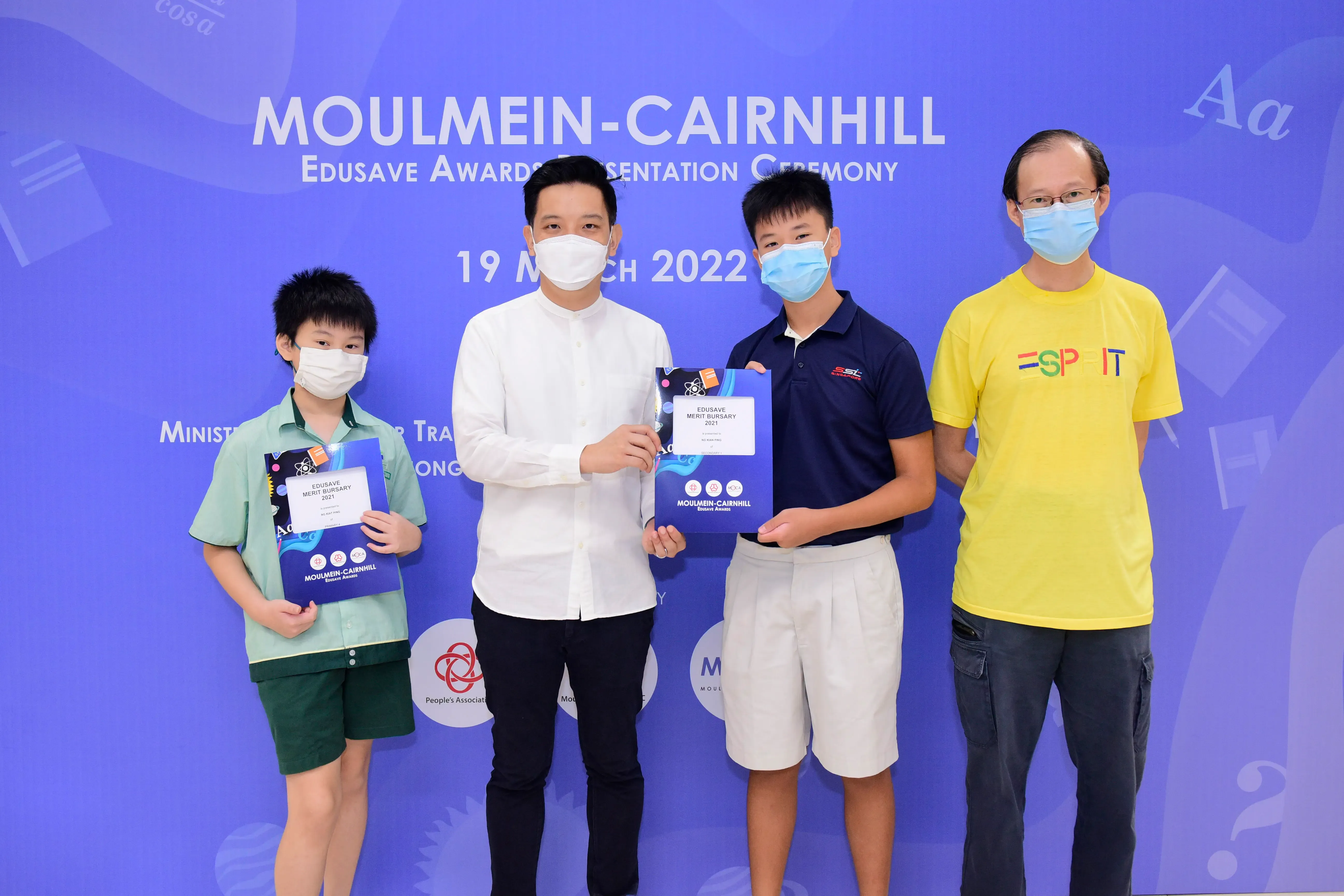 Four masked people pose at the Moulmein-Cairnhill Edusave Awards Presentation Ceremony on 19 March 2022.