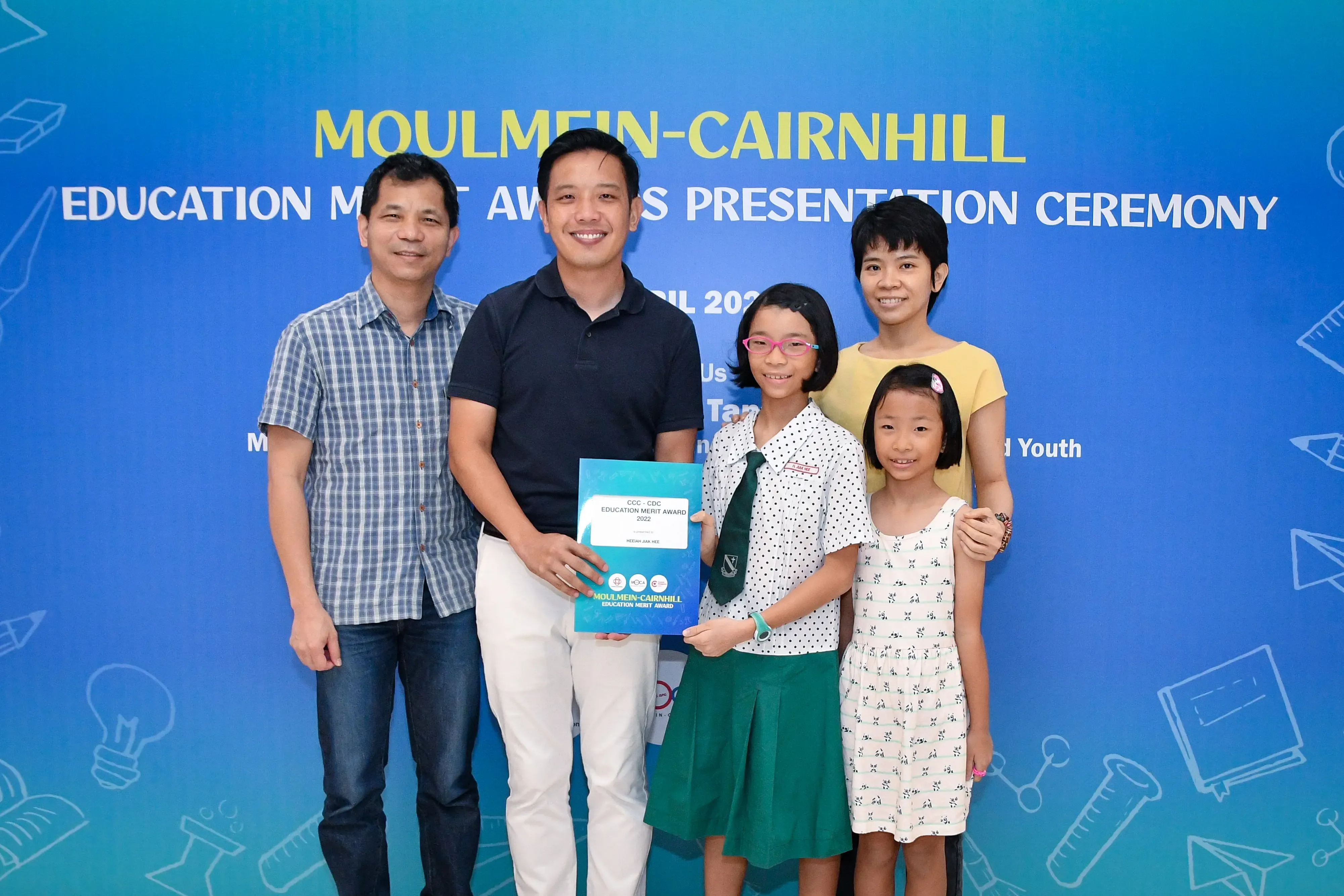 Five people pose with an award certificate at the Moulmein-Cairnhill Education Merit Awards Presentation Ceremony.