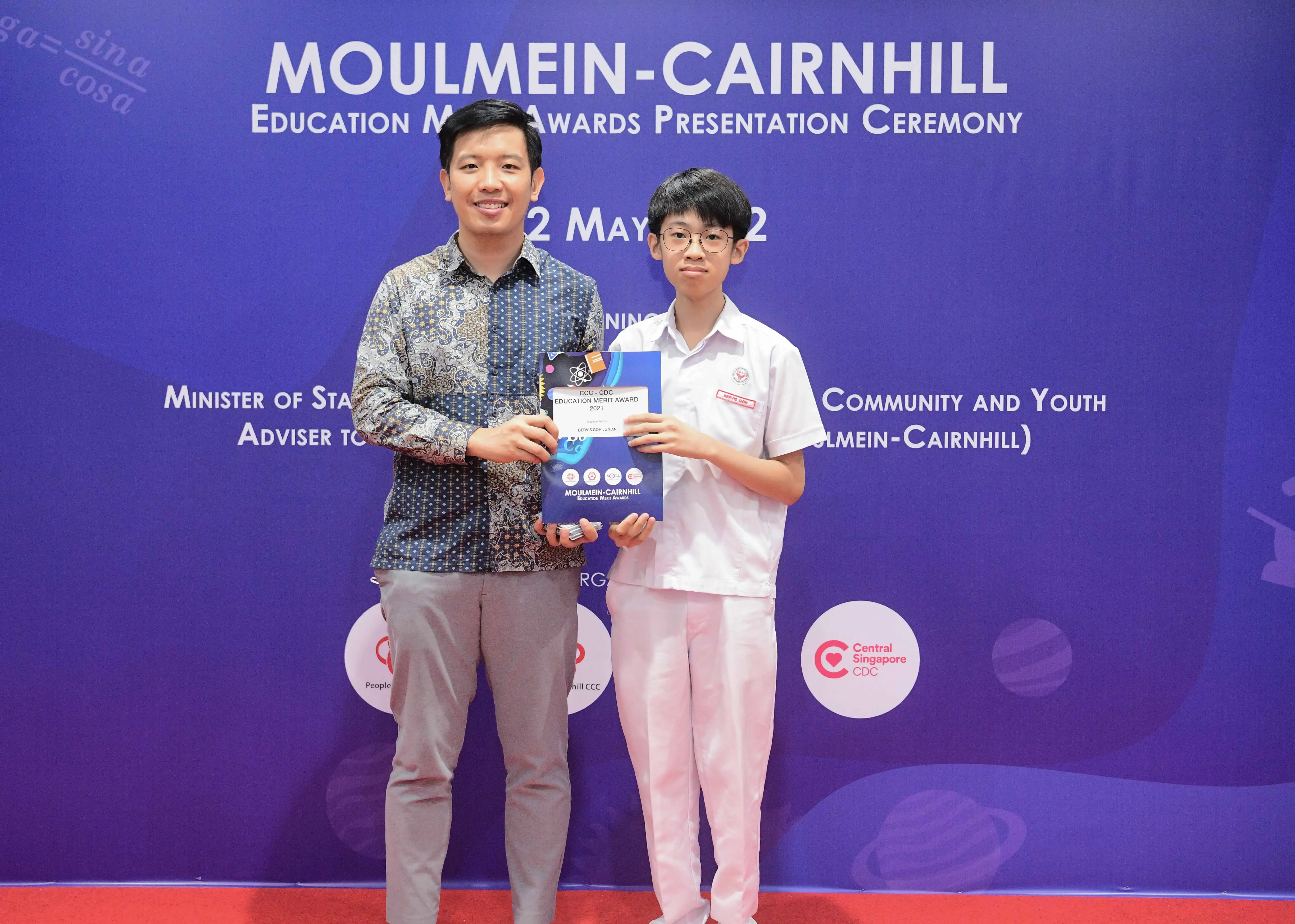 Two people pose holding an award at the Moulmein-Cairnhill Education Merit Awards Presentation Ceremony.