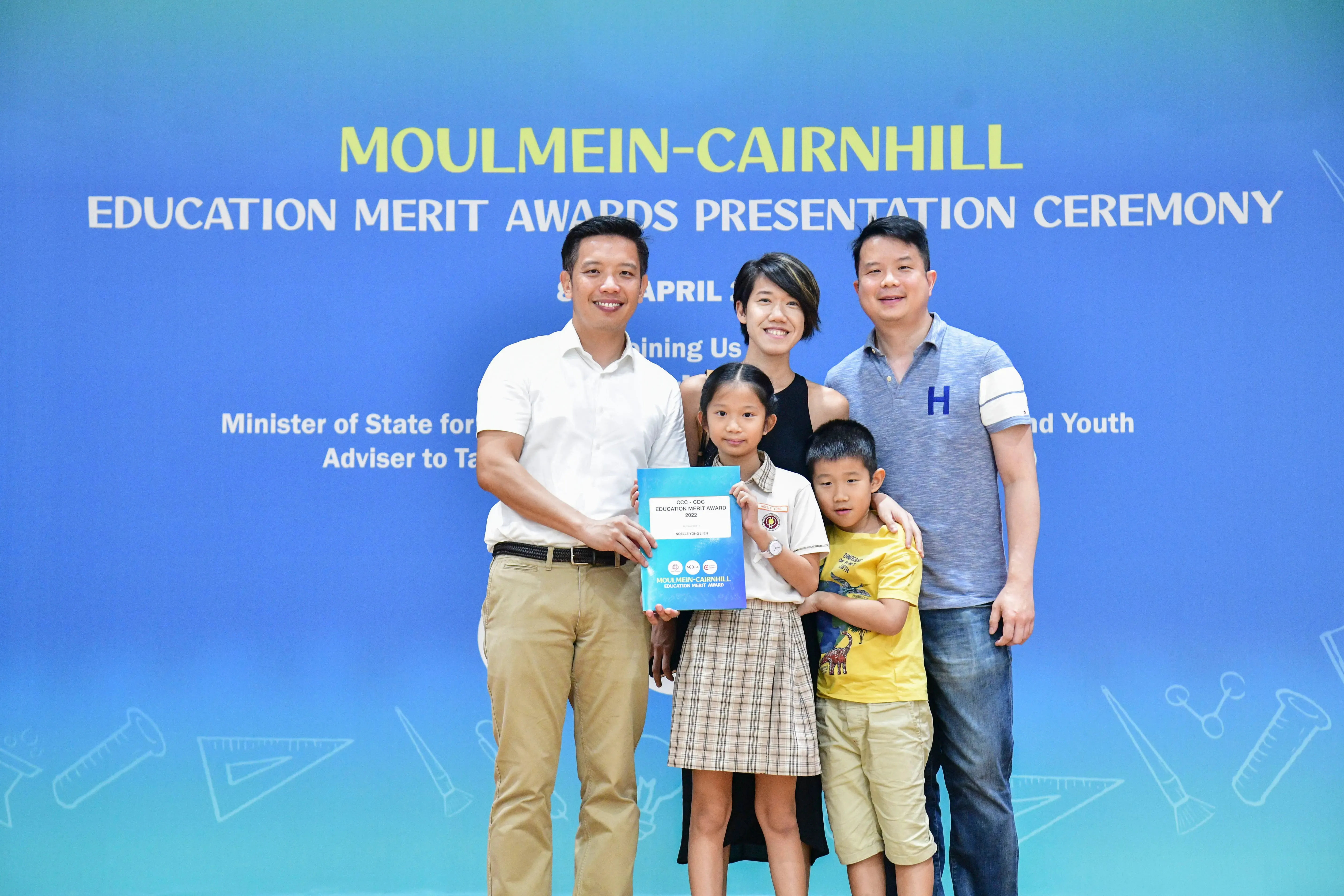 Five people pose with a certificate at the Moulmein-Cairnhill Education Merit Awards Presentation Ceremony.