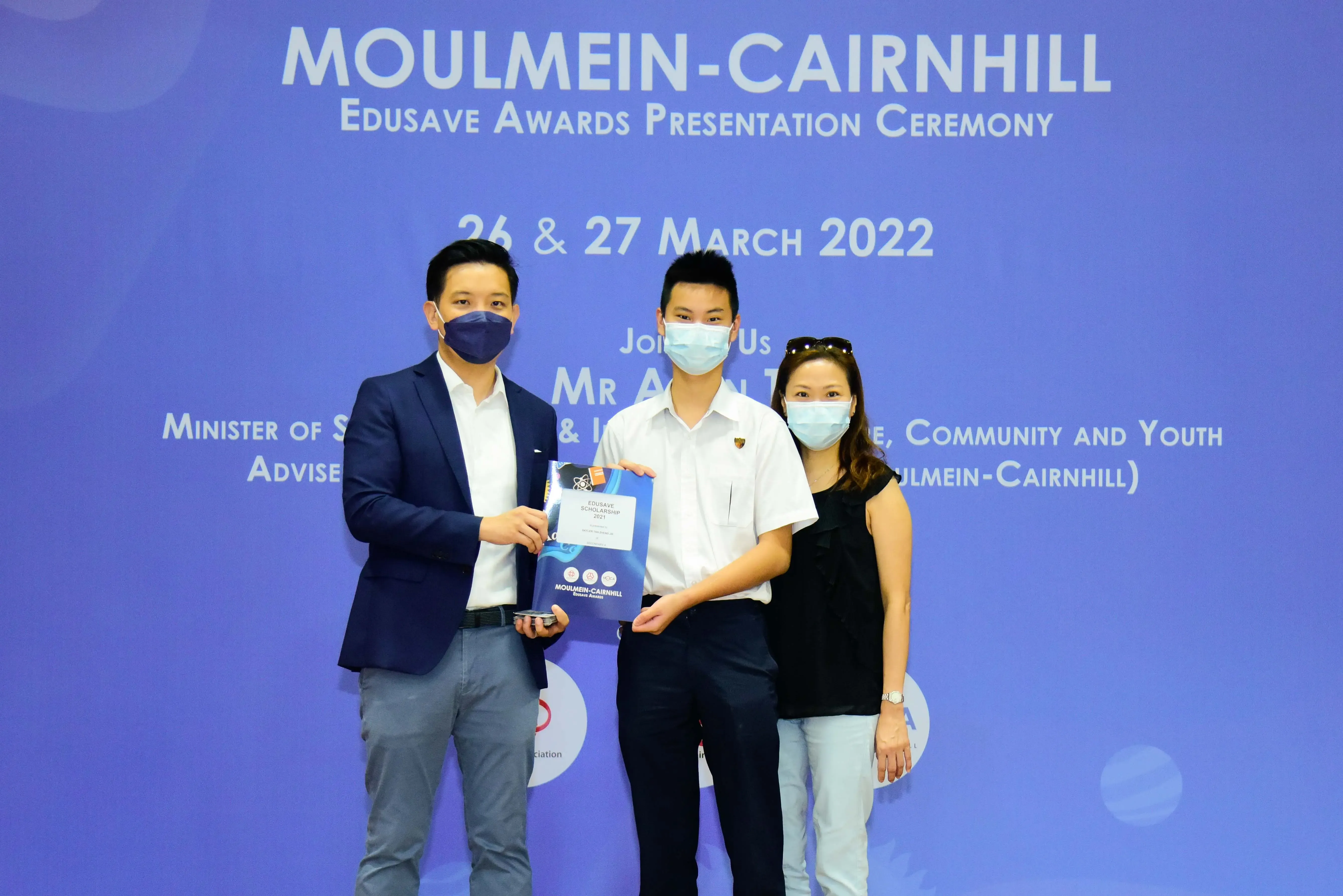 Three masked people pose at the Moulmein-Cairnhill Edusave Awards Presentation Ceremony on 26 & 27 March 2022.