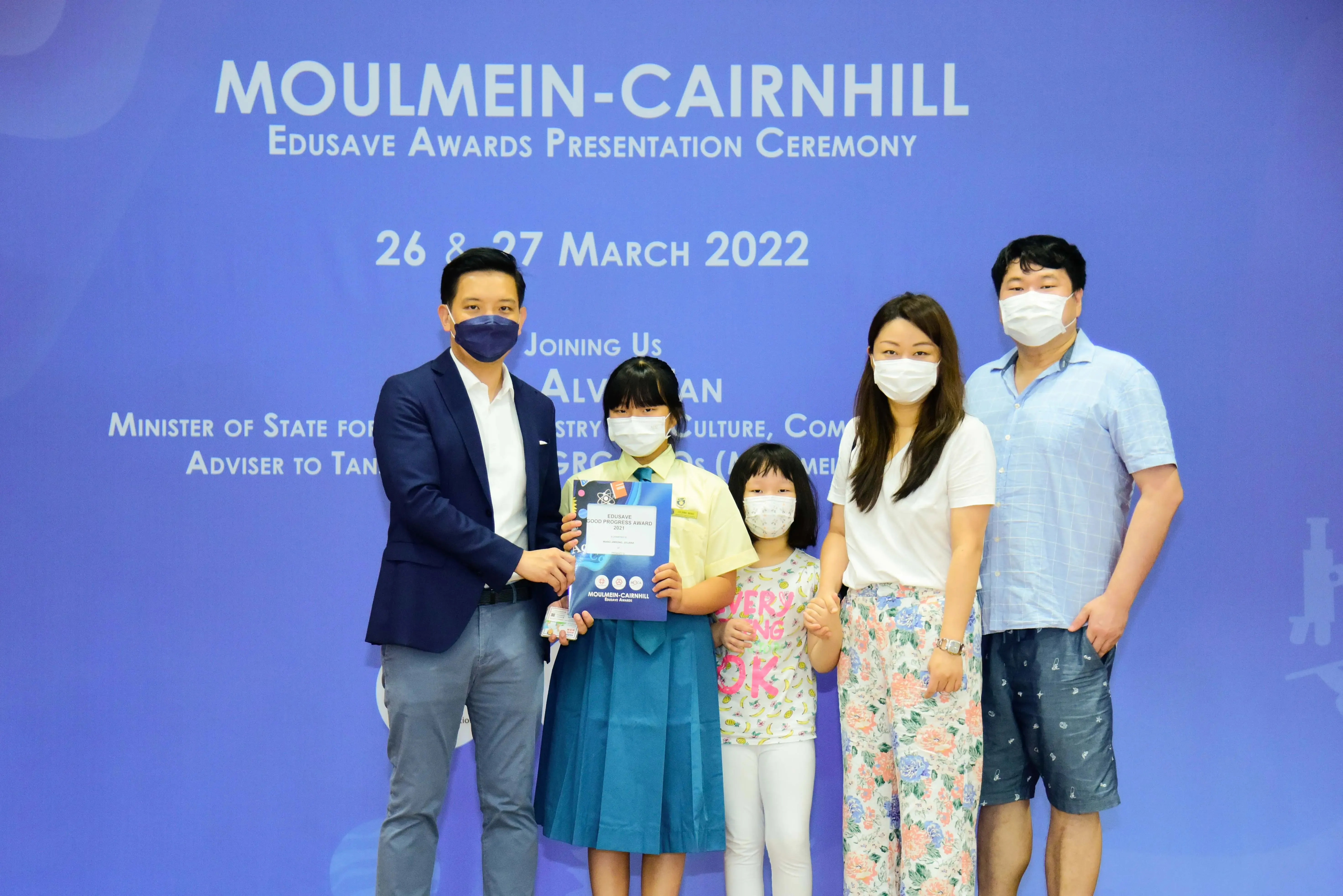 Five masked people pose at the Moulmein-Cairnhill Edusave Awards Presentation Ceremony on 26-27 March 2022.