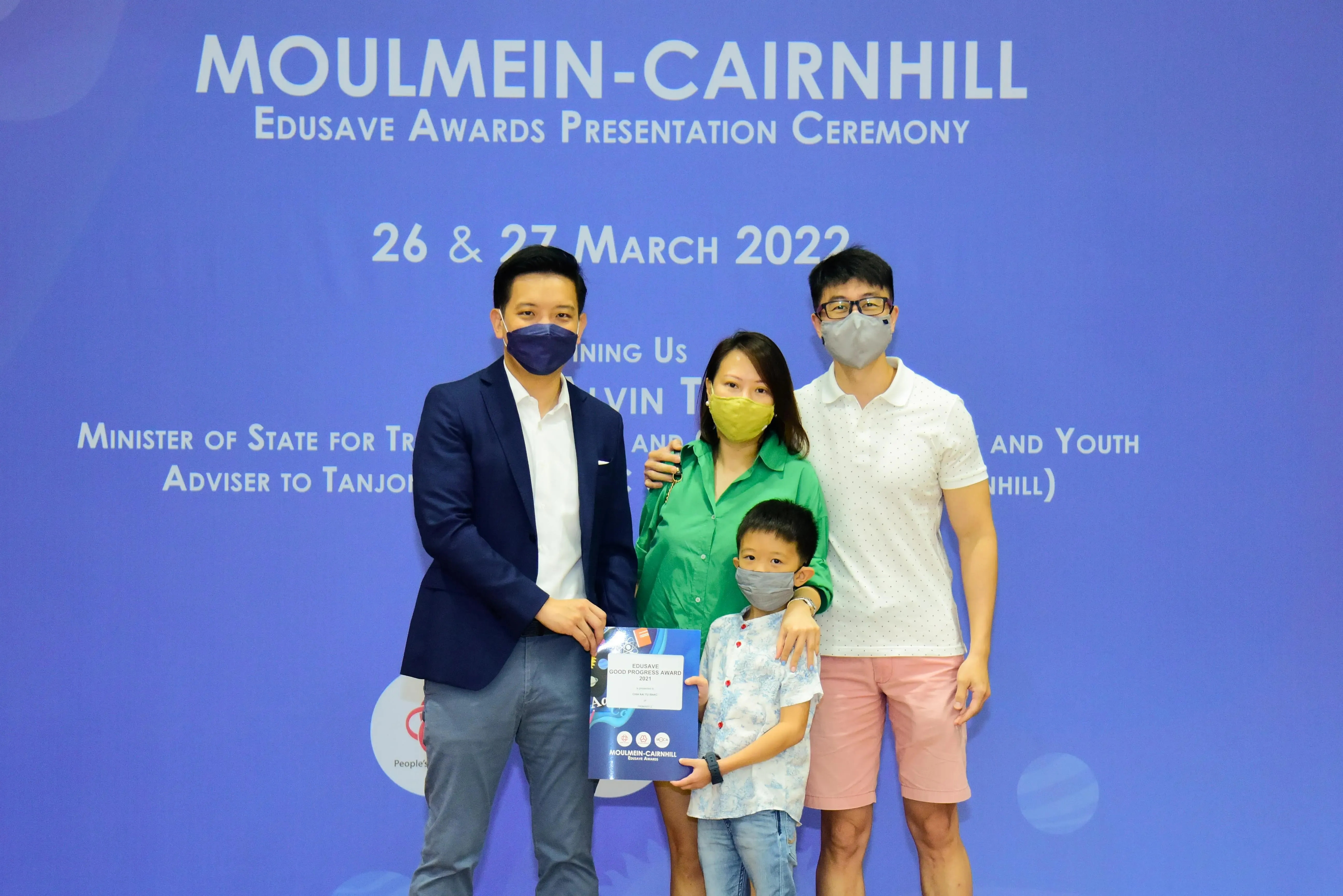 Four masked people pose at the Moulmein-Cairnhill Edusave Awards Presentation Ceremony on 26 & 27 March 2022.