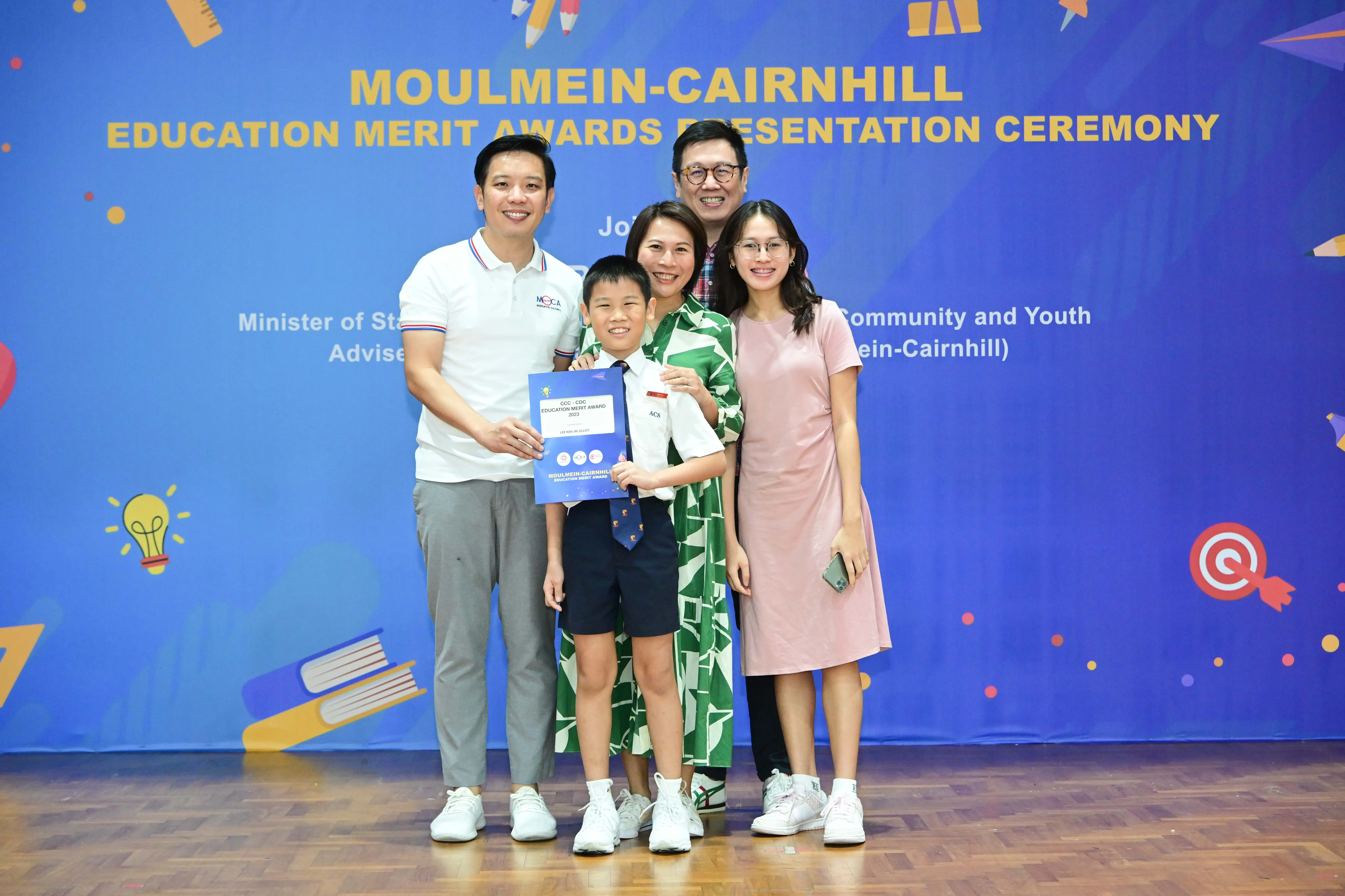 Five people pose with a certificate at the Moulmein-Cairnhill Education Merit Awards Presentation Ceremony.