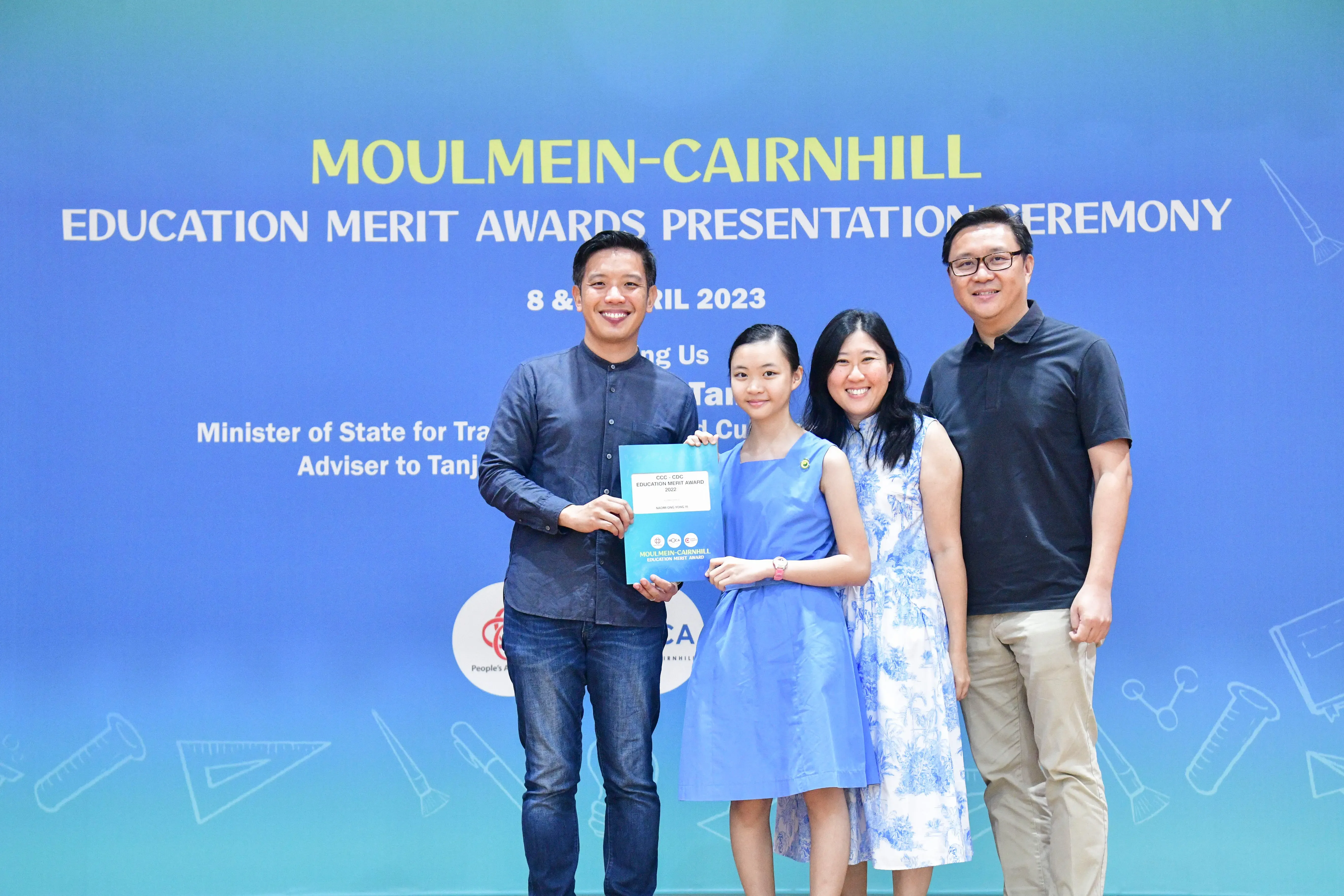 Four people pose smiling at the Moulmein-Cairnhill Education Merit Awards Presentation Ceremony in April 2023.