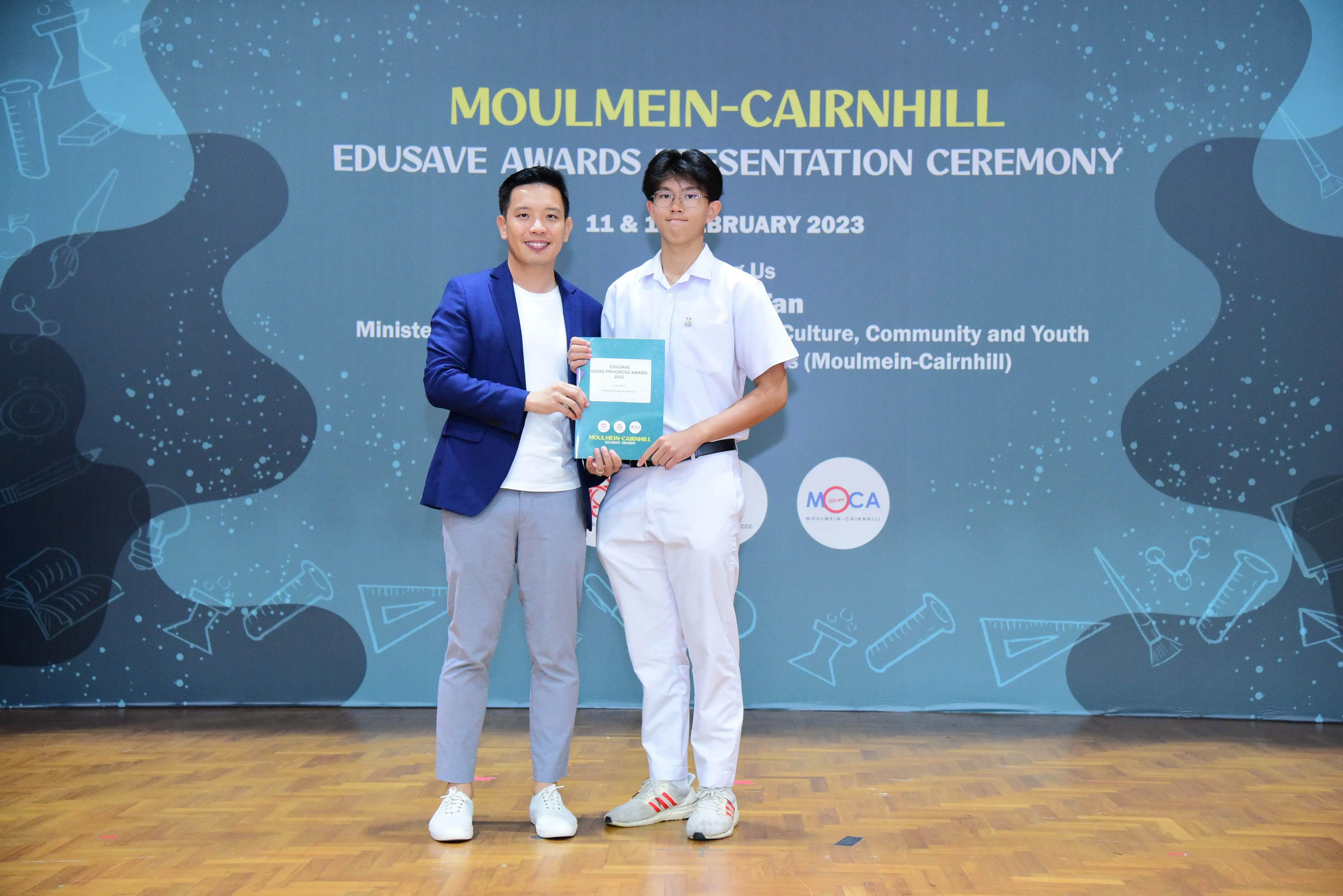 Two men pose holding a certificate at the Moulmein-Cairnhill Edusave Awards Presentation Ceremony, February 2023.