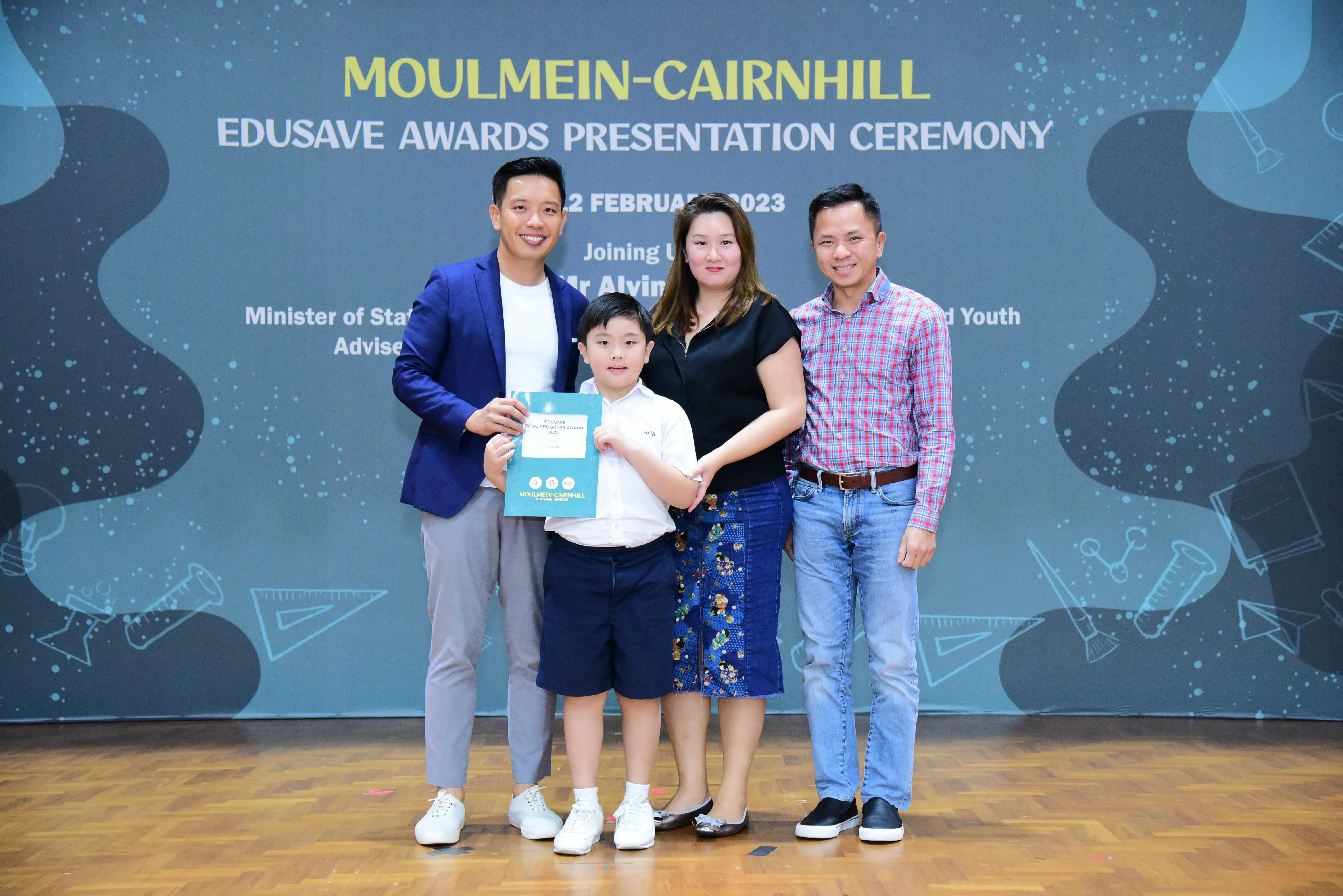 Four people pose with a certificate at the Moulmein-Cairnhill Edusave Awards Presentation Ceremony, February 2023.