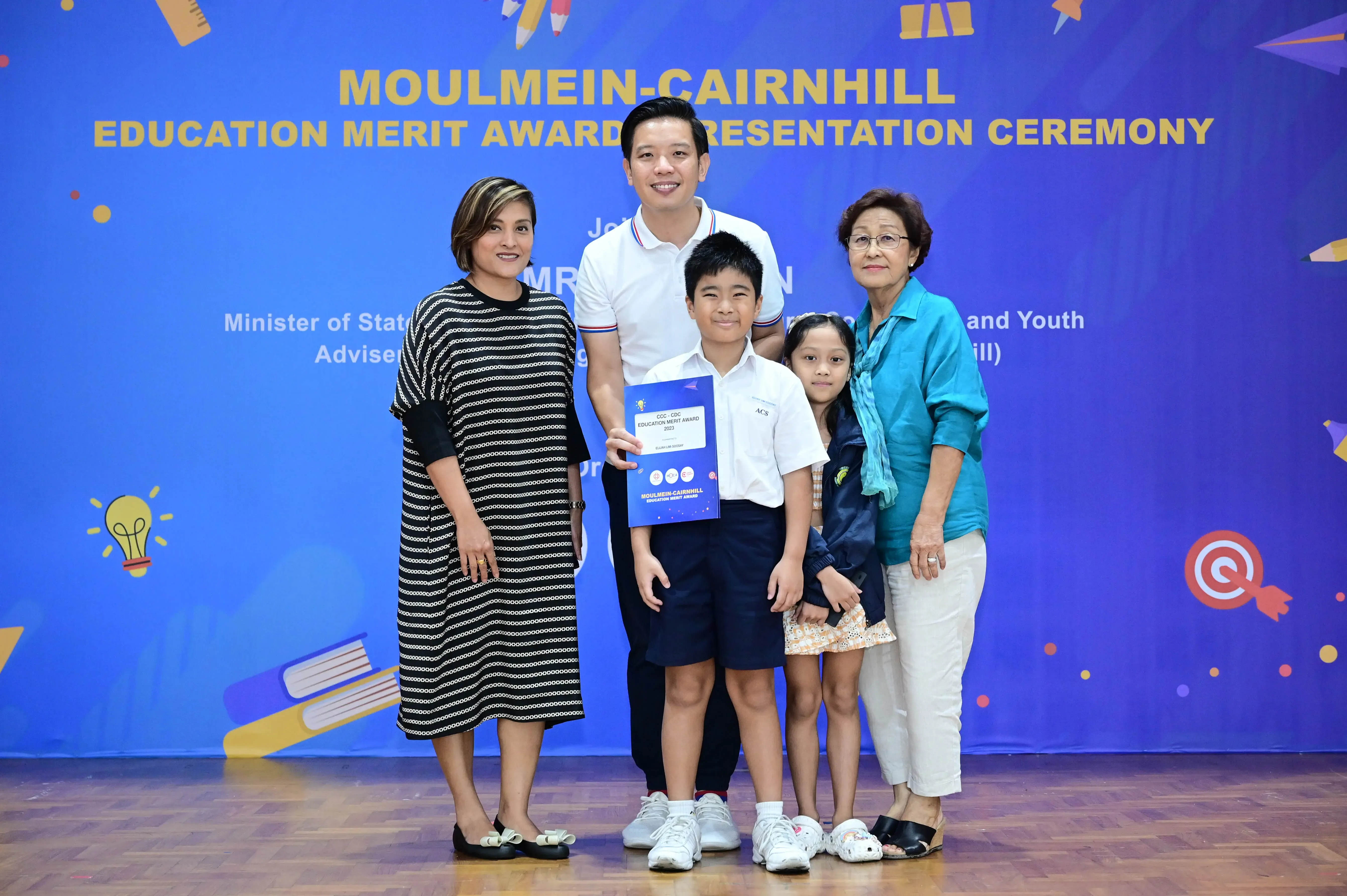 Five people pose with an award certificate at the Moulmein-Cairnhill Education Merit Award Presentation Ceremony.