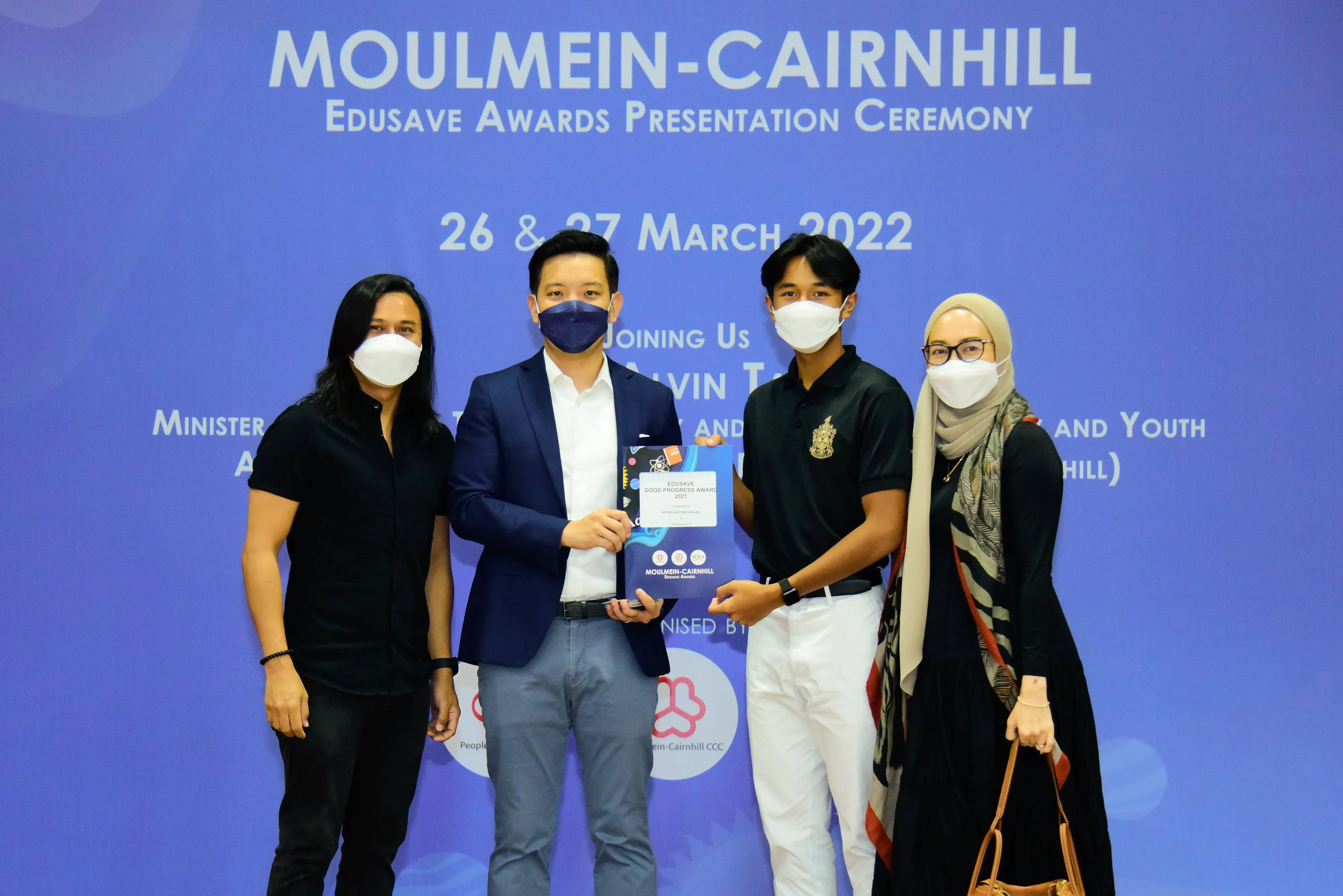 Four masked people pose at the Moulmein-Cairnhill Edusave Awards Presentation Ceremony on 26-27 March 2022.