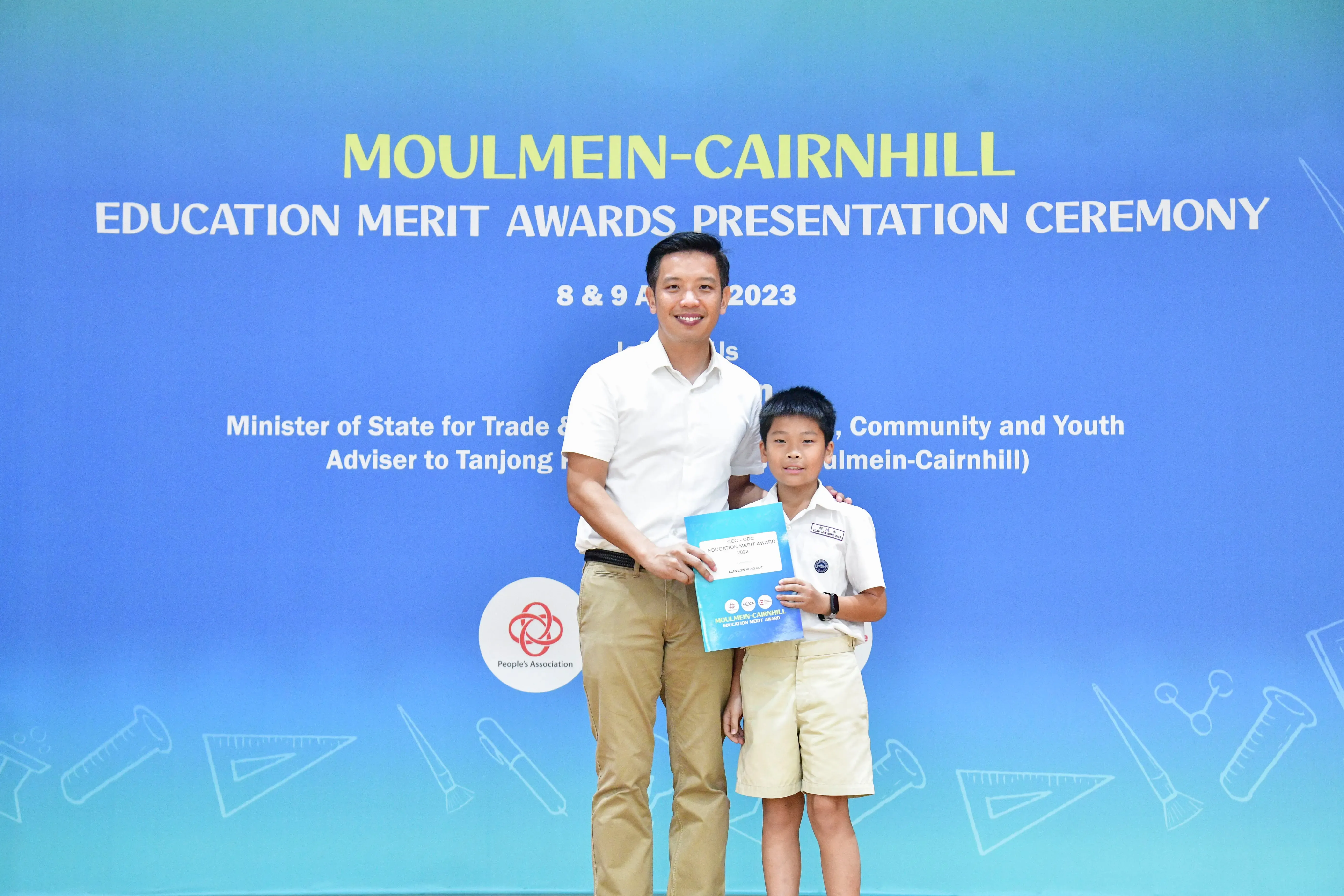A man and a young boy pose together holding an award certificate at the Moulmein-Cairnhill Education Merit Awards 2023.