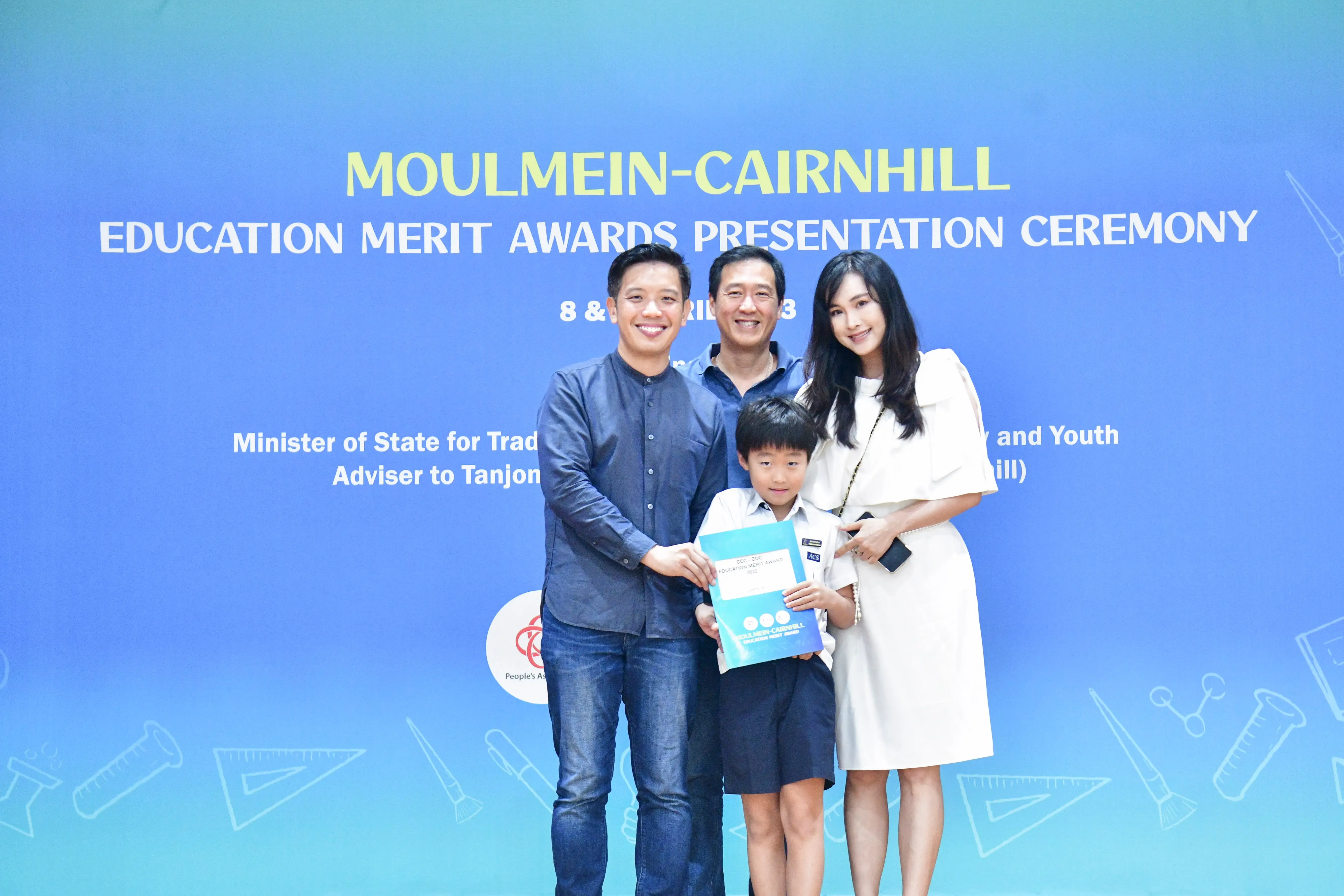 Three adults and a young boy pose with an award at the Moulmein-Cairnhill Education Merit Awards Presentation Ceremony.